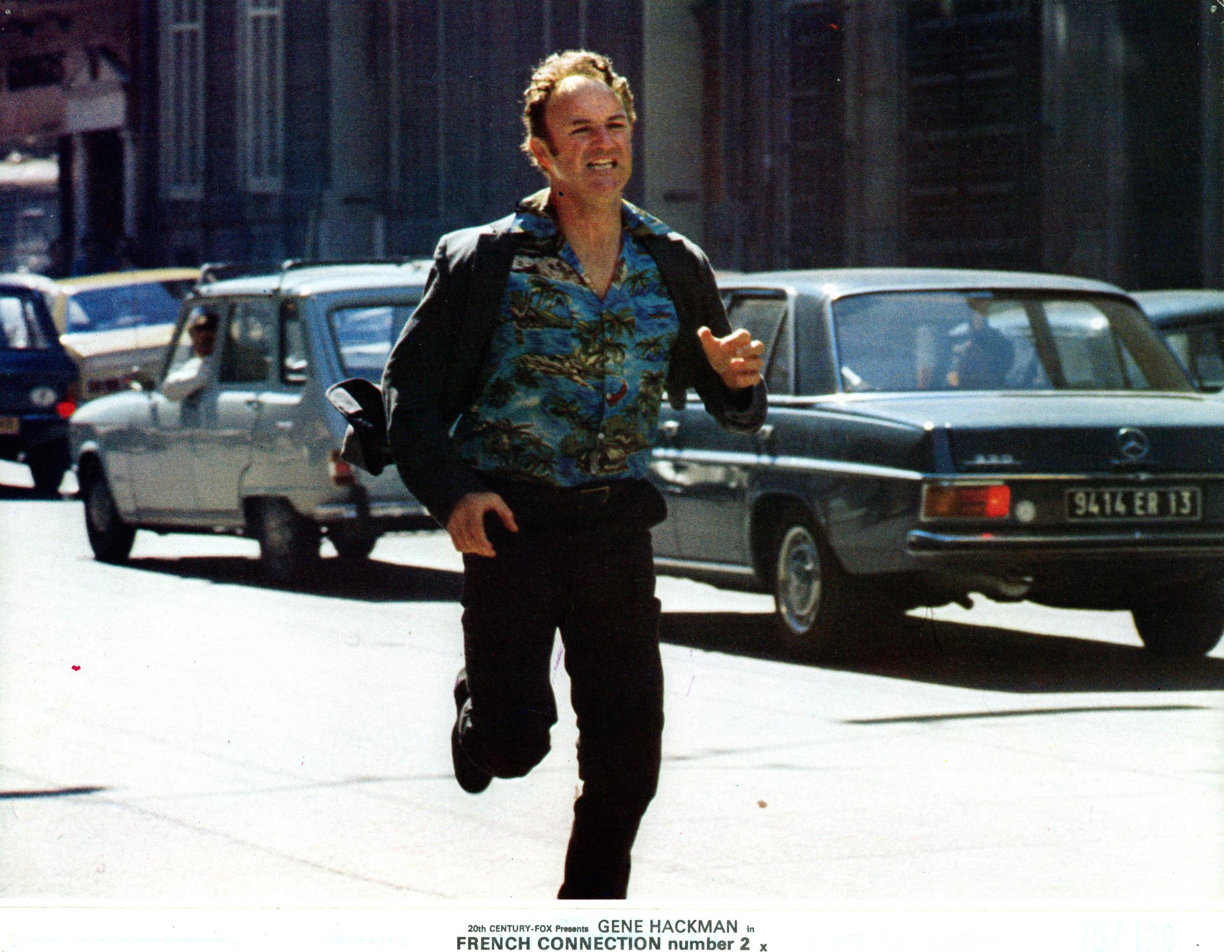 Gene Hackman runs down the street in a scene from the film "French Connection II," in 1975 | Source: Getty Images