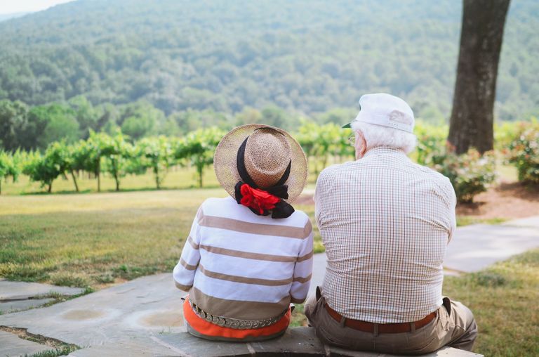 An elderly couple is sitting in the green field.  |  Source: Unsplash