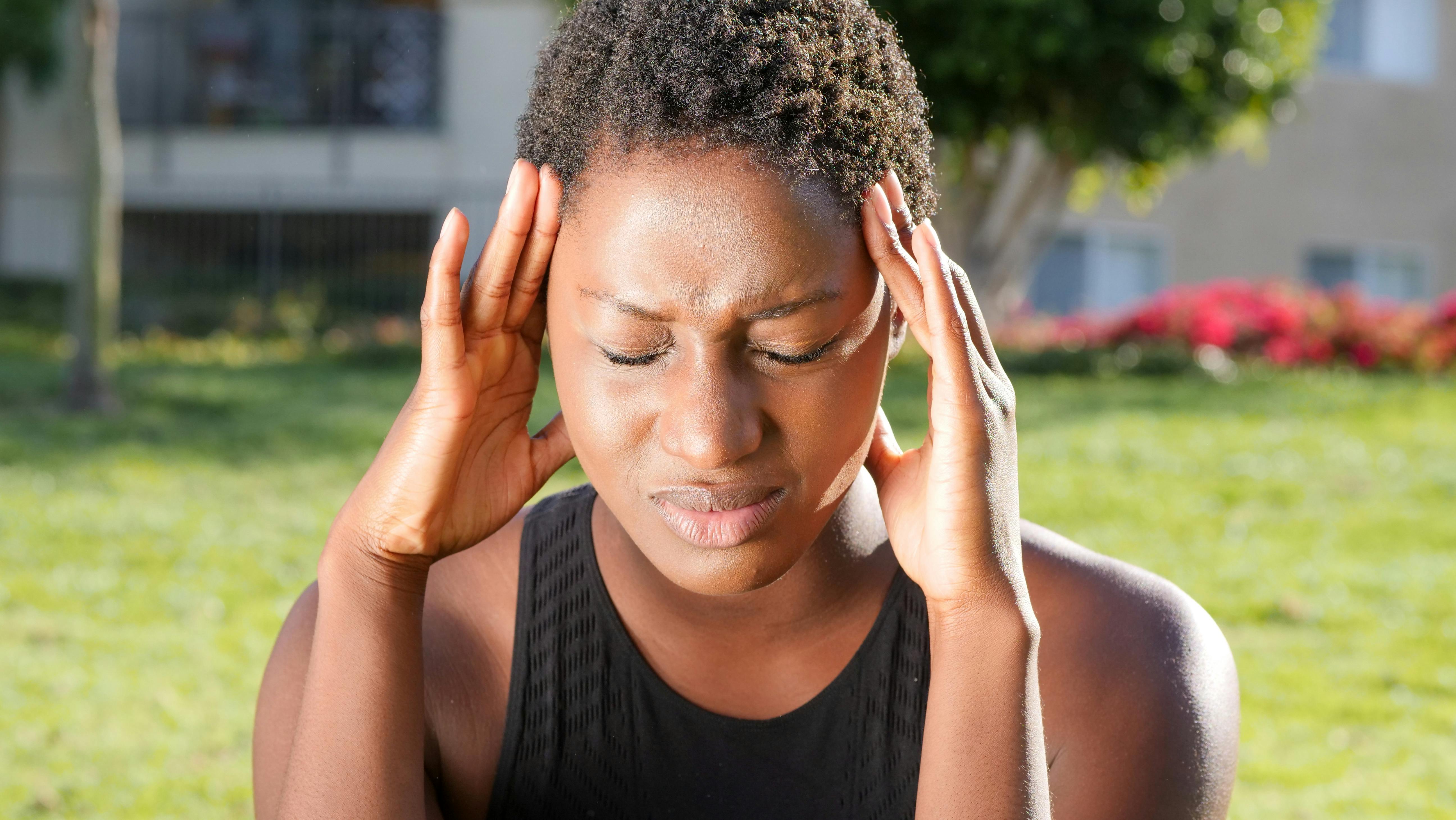 A woman holding her head in pain. | Source: Pexels