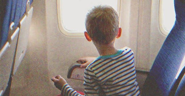 Child looking out airplane window | Source: Shutterstock