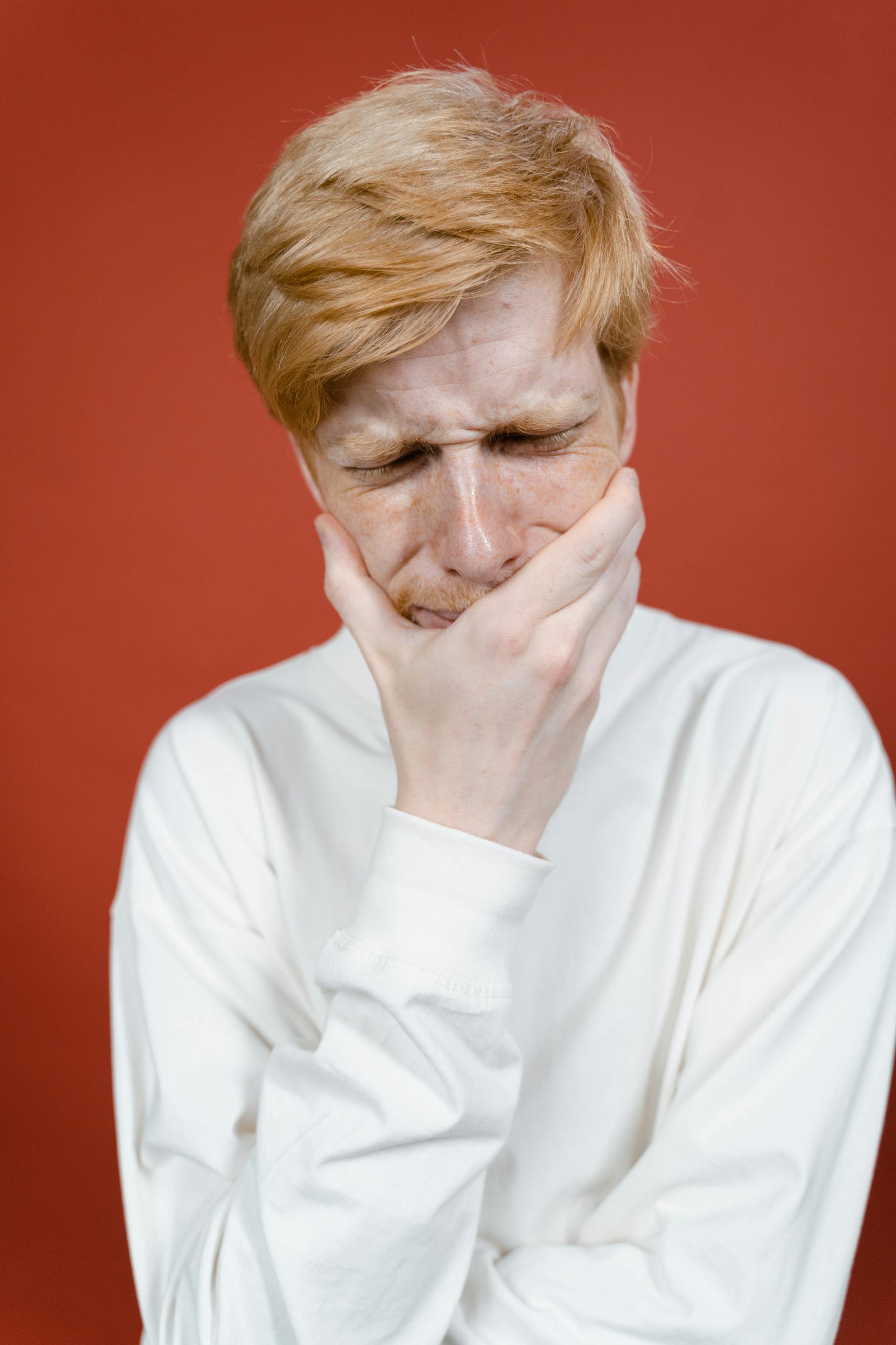 An anxious man holding his face | Source: Pexels