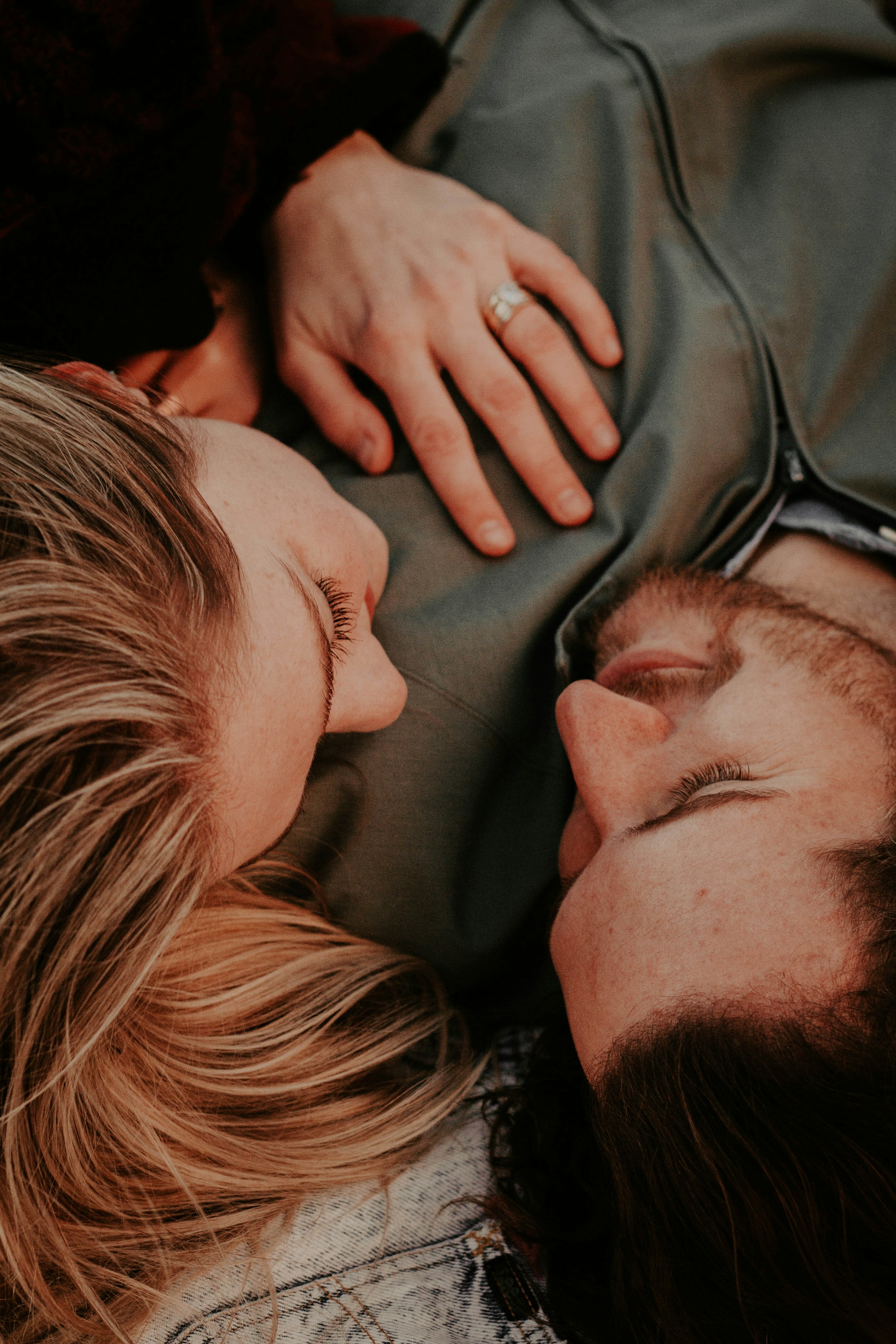 A couple lovingly looks into each other's eyes while lying side by side | Source: Unsplash