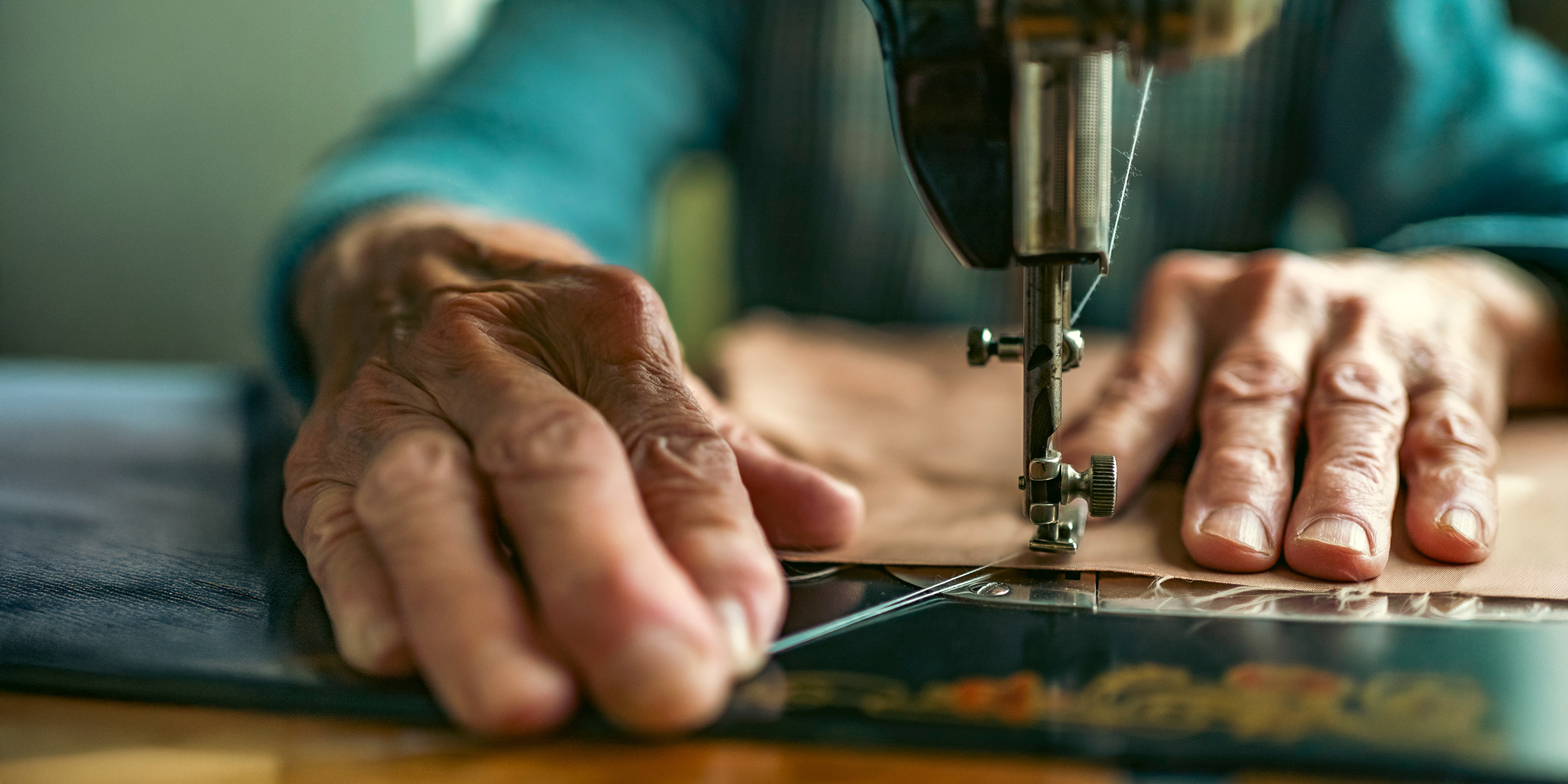 An elderly woman using a sewing machine | Source: Shutterstock