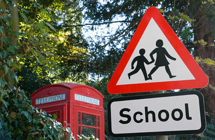 School ahead sign positioned in front of a telephone box, Kent, England | Source: Getty Images