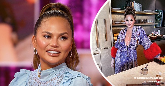Chrissy Teigen Bares Her Cleavage As She Poses In Her Kitchen In A Low Cut Floral Dress