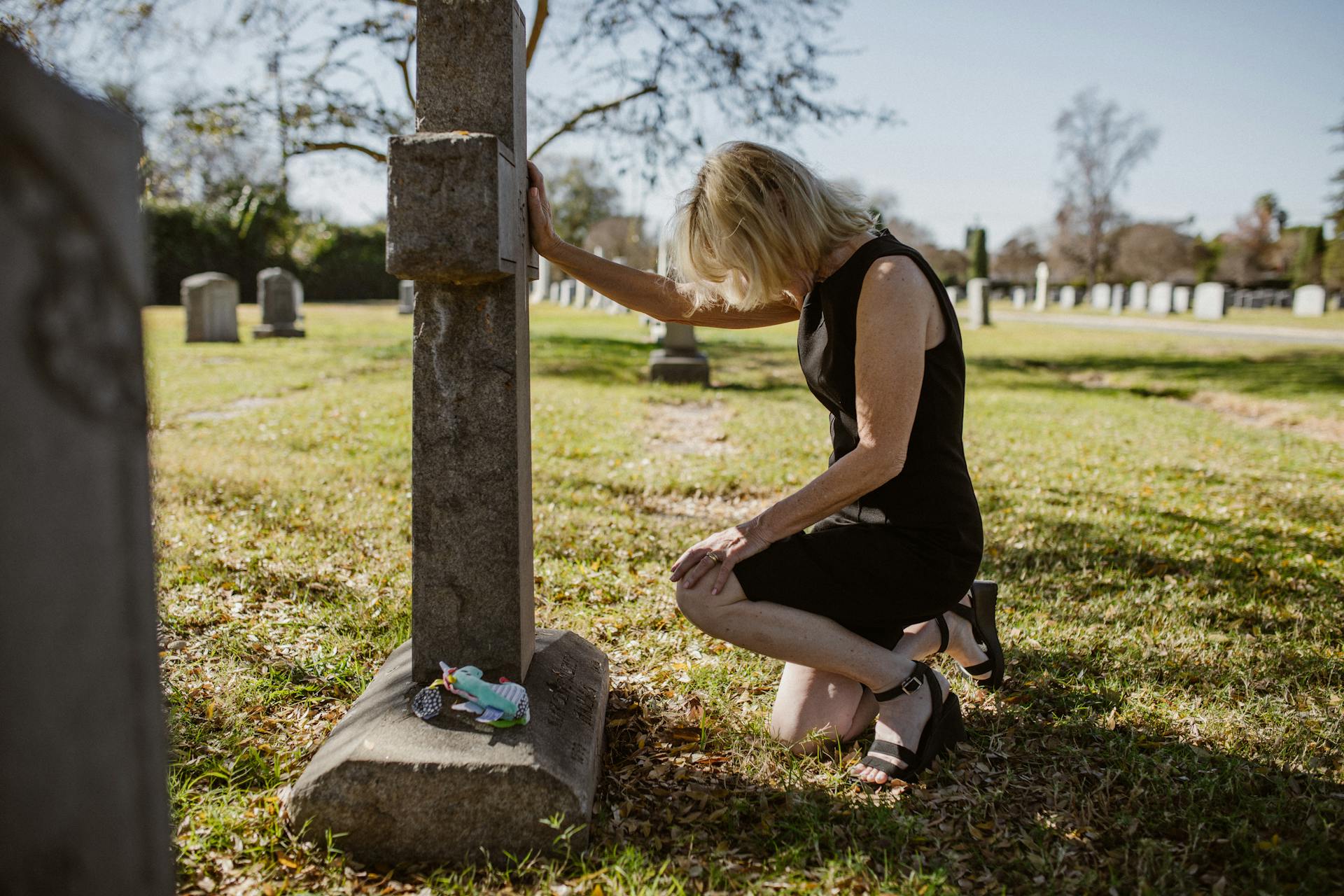 A woman sitting near a grave | Source: Pexels