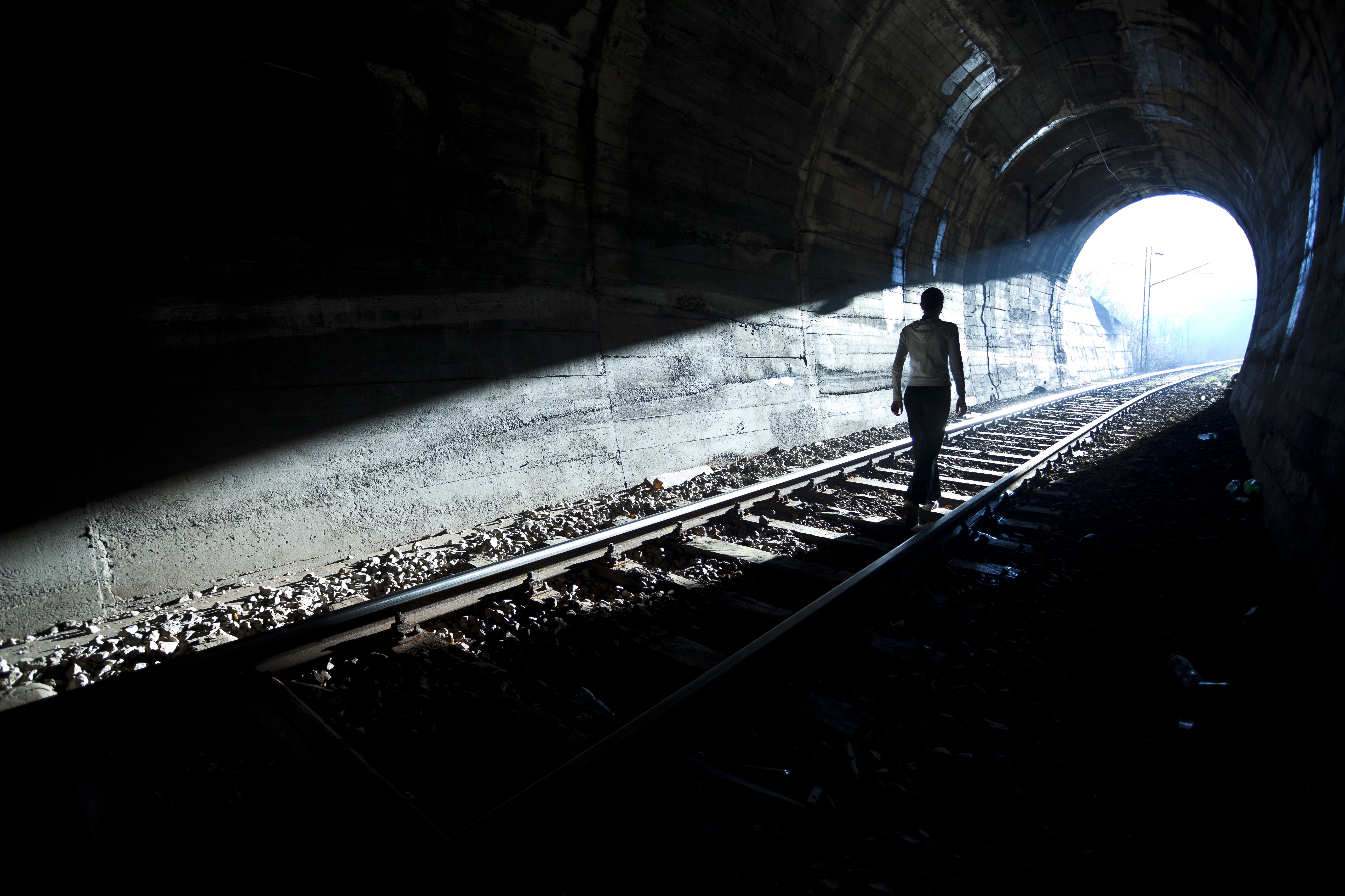 Mujer sigue la luz hasta salida del túnel. | Fuente: Shutterstock Mujer sigue la luz hasta salida del túnel. | Fuente: Shutterstock