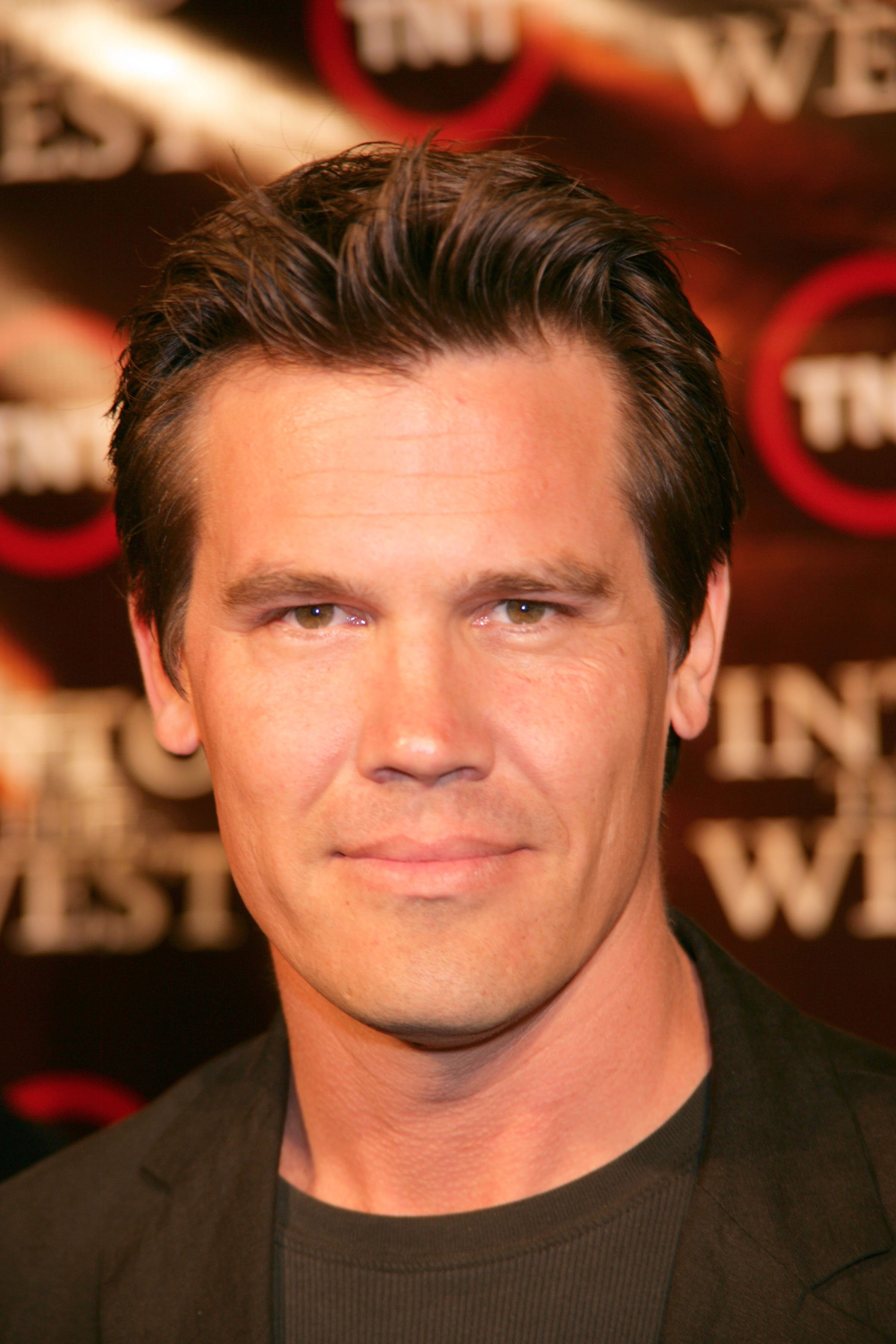 Hair neatly styled and face clean-shaven, he appears with smooth skin, no visible tattoos, and a neutral expression. His look remains understated, still far from the dramatic changes to come.