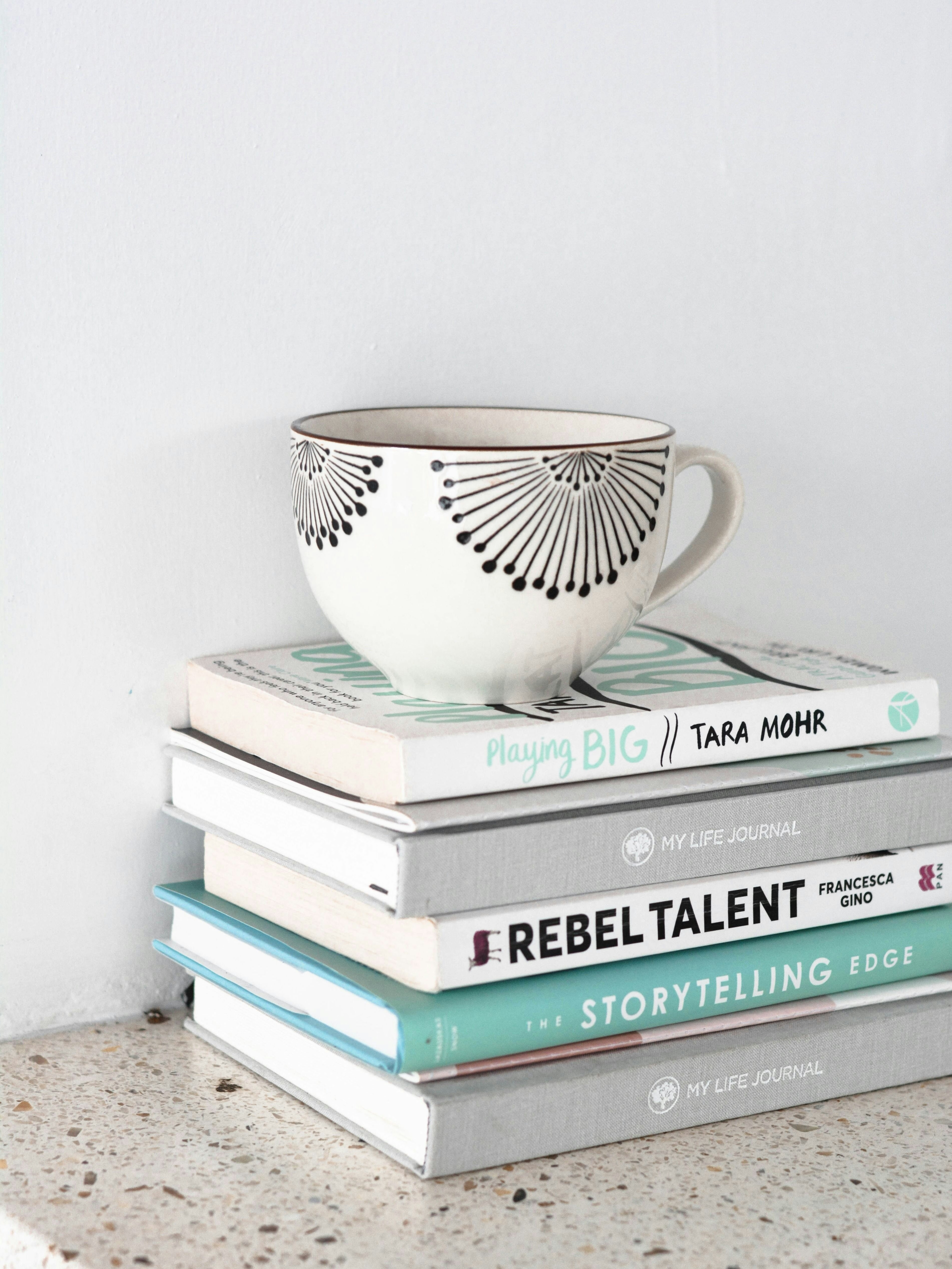 Pile of books and cup on top | Source: Unsplash