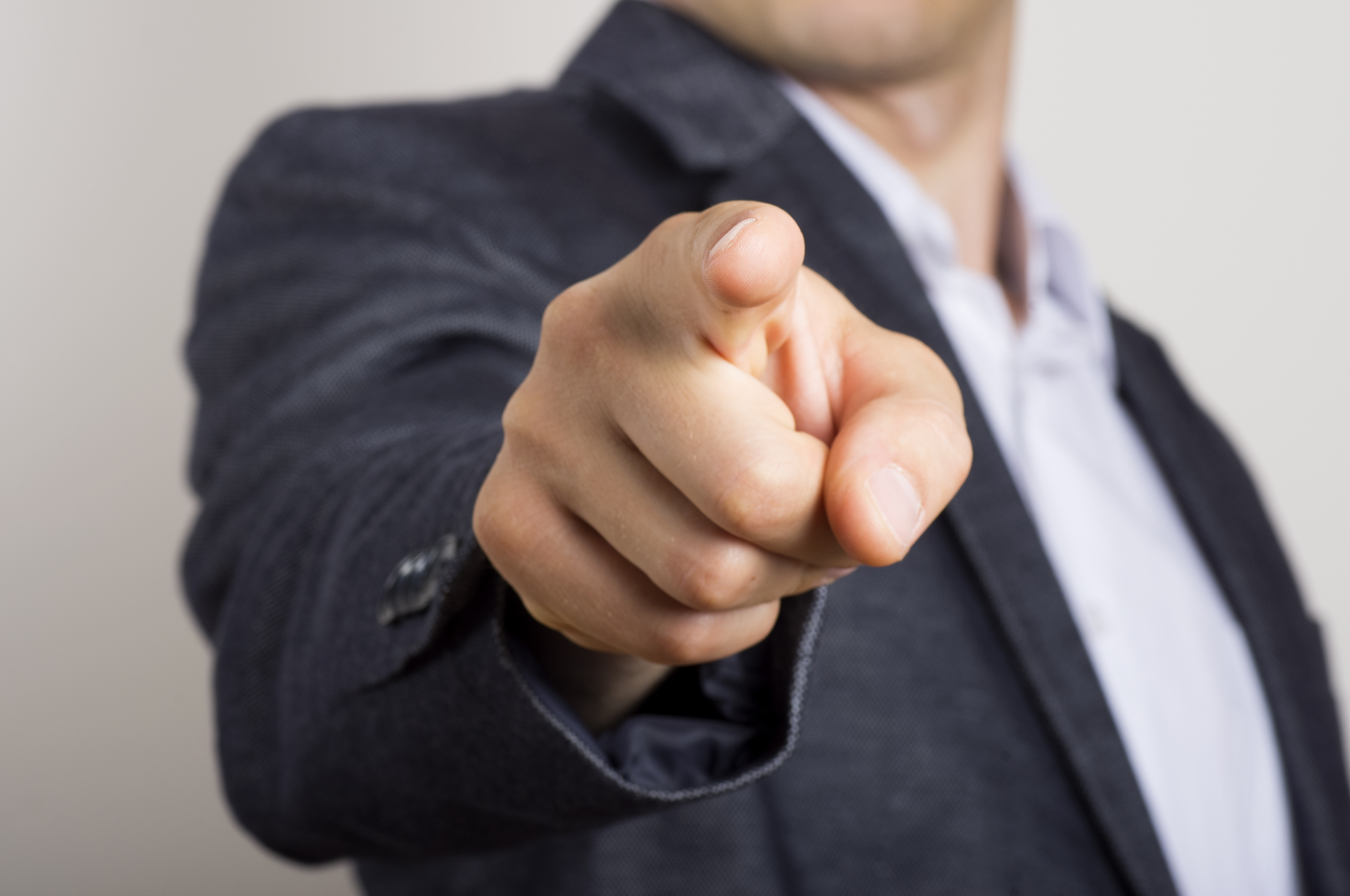 Business man points his finger at someone. | Source: Shutterstock