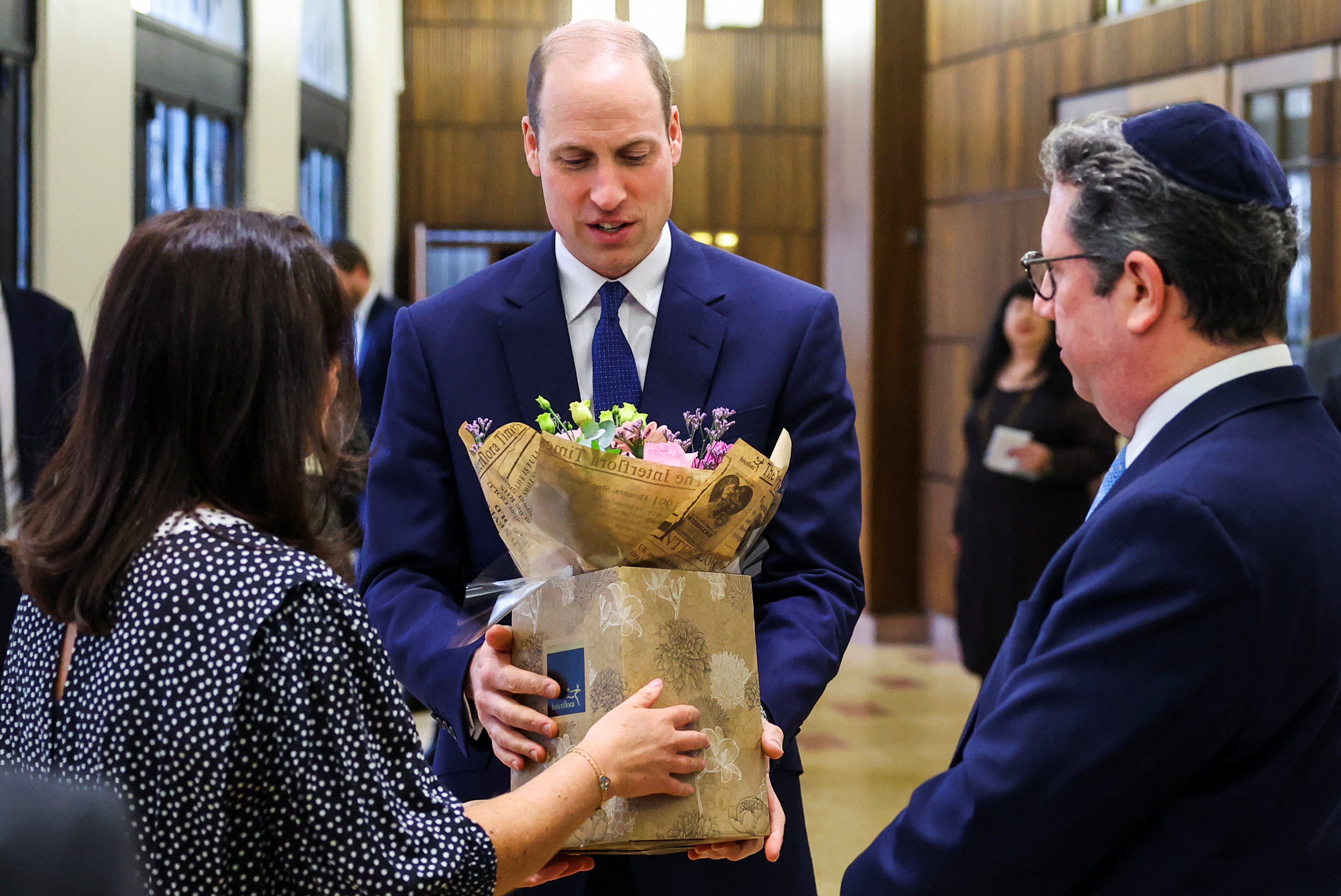 Prince William speaks receives a bouquet of flowers during a visit to the Western Marble Arch Synagogue on February 29, 2024 in London, England. | Source: Getty Images