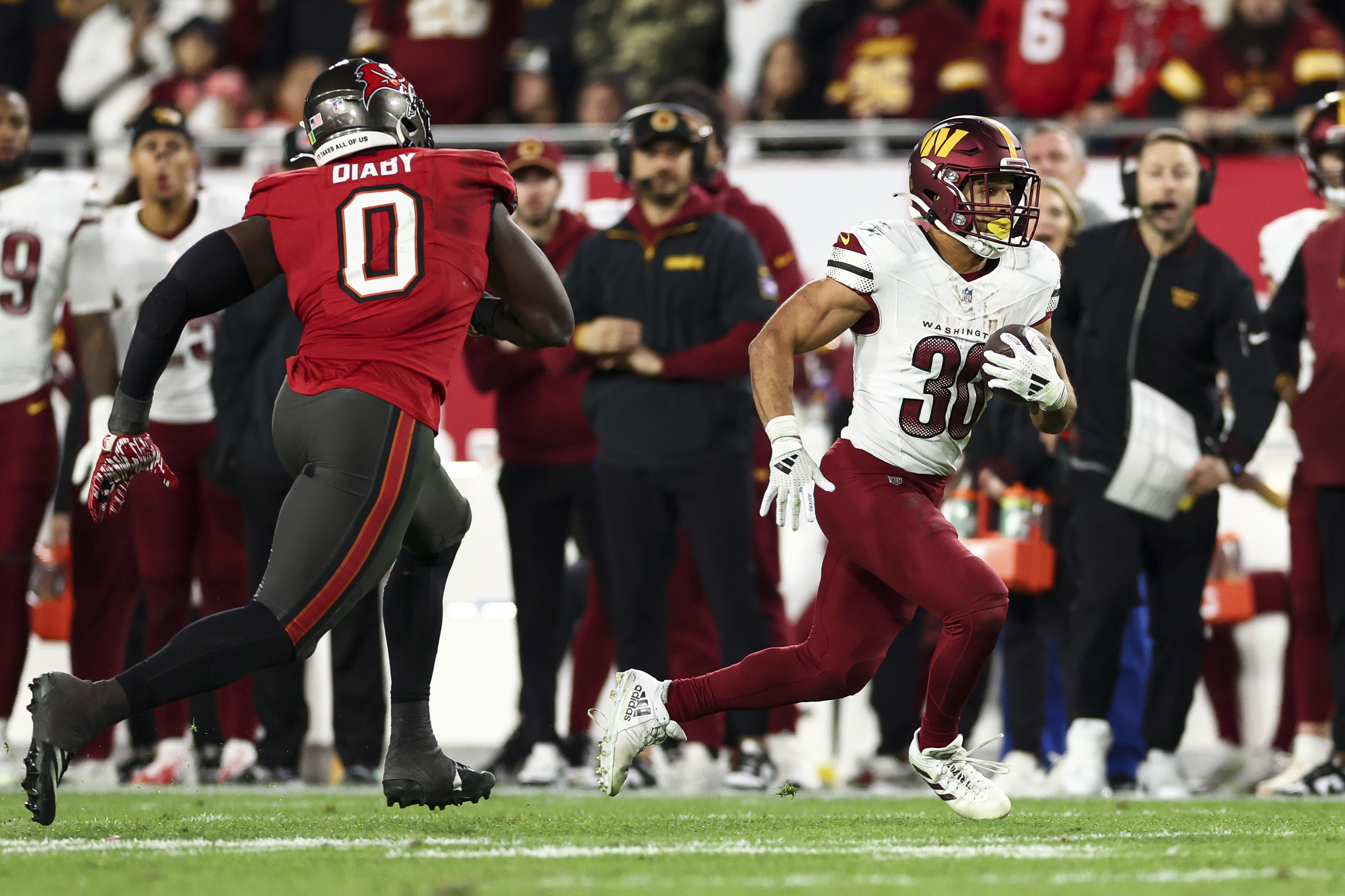 Austin Ekeler #30 of the Washington Commanders carries the ball during the game against the Tampa Bay Buccaneers on January 12, 2025, in Tampa, Florida | Source: Getty Images