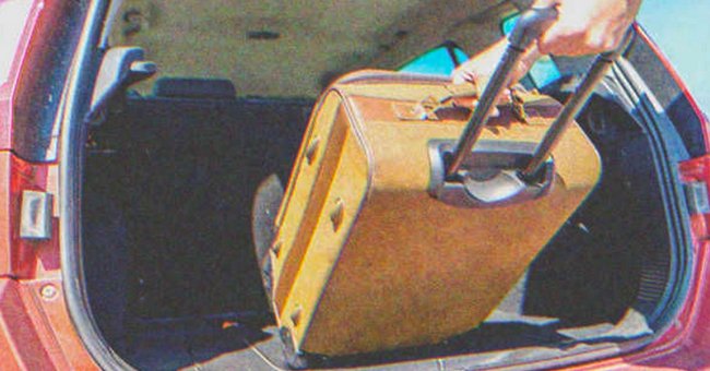 A person loading a suitcase into a car | Source: Shutterstock