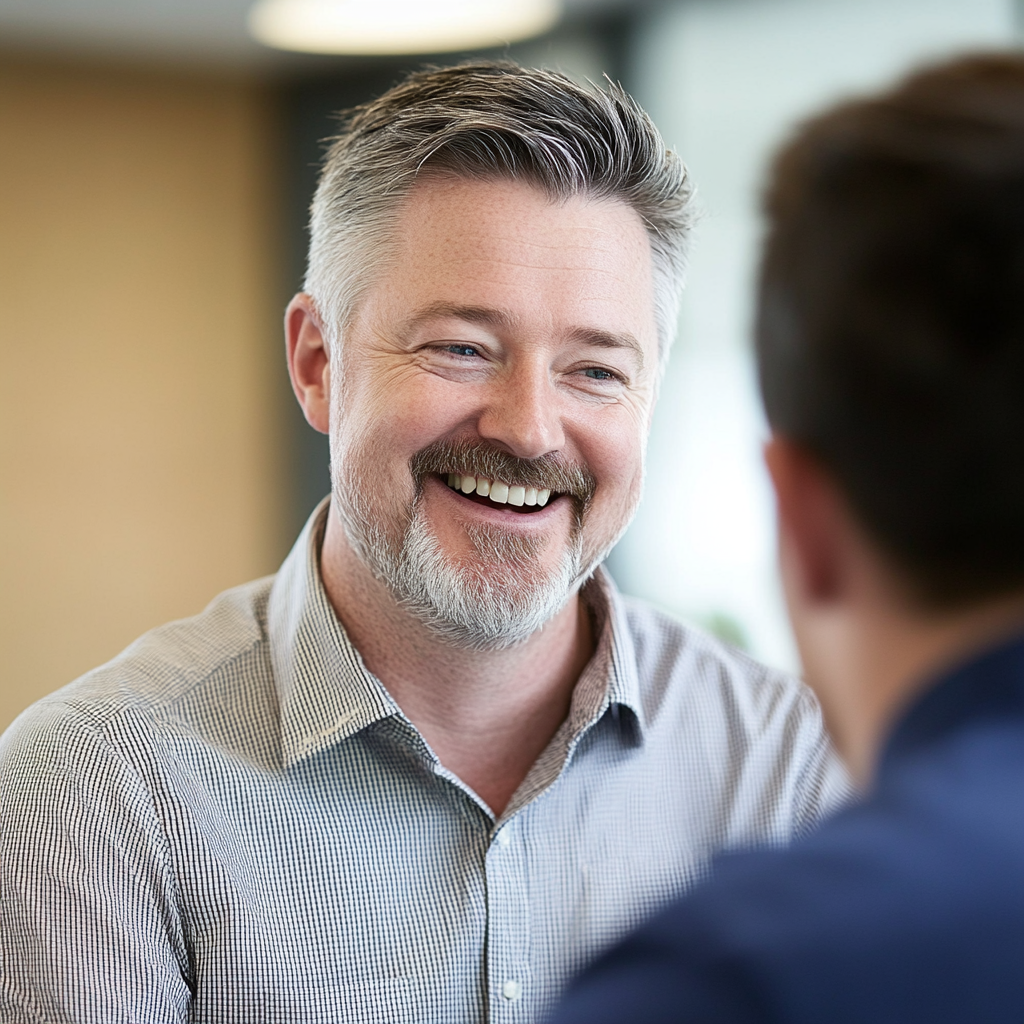 A man laughs while delivering the perfect comeback to a fellow work colleague | Source: Midjourney