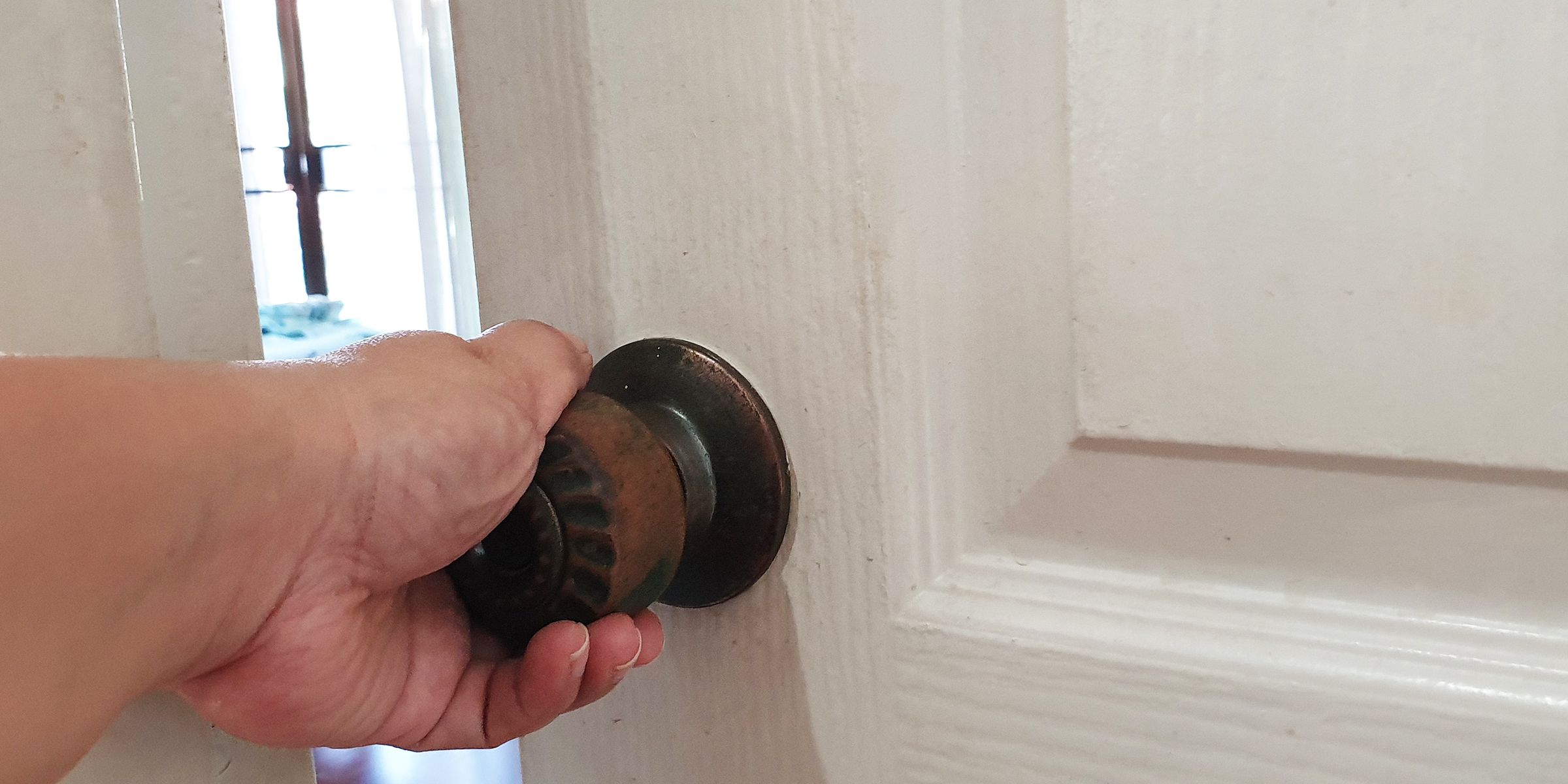 A Man's Hand Opening a Door | Source: Shutterstock