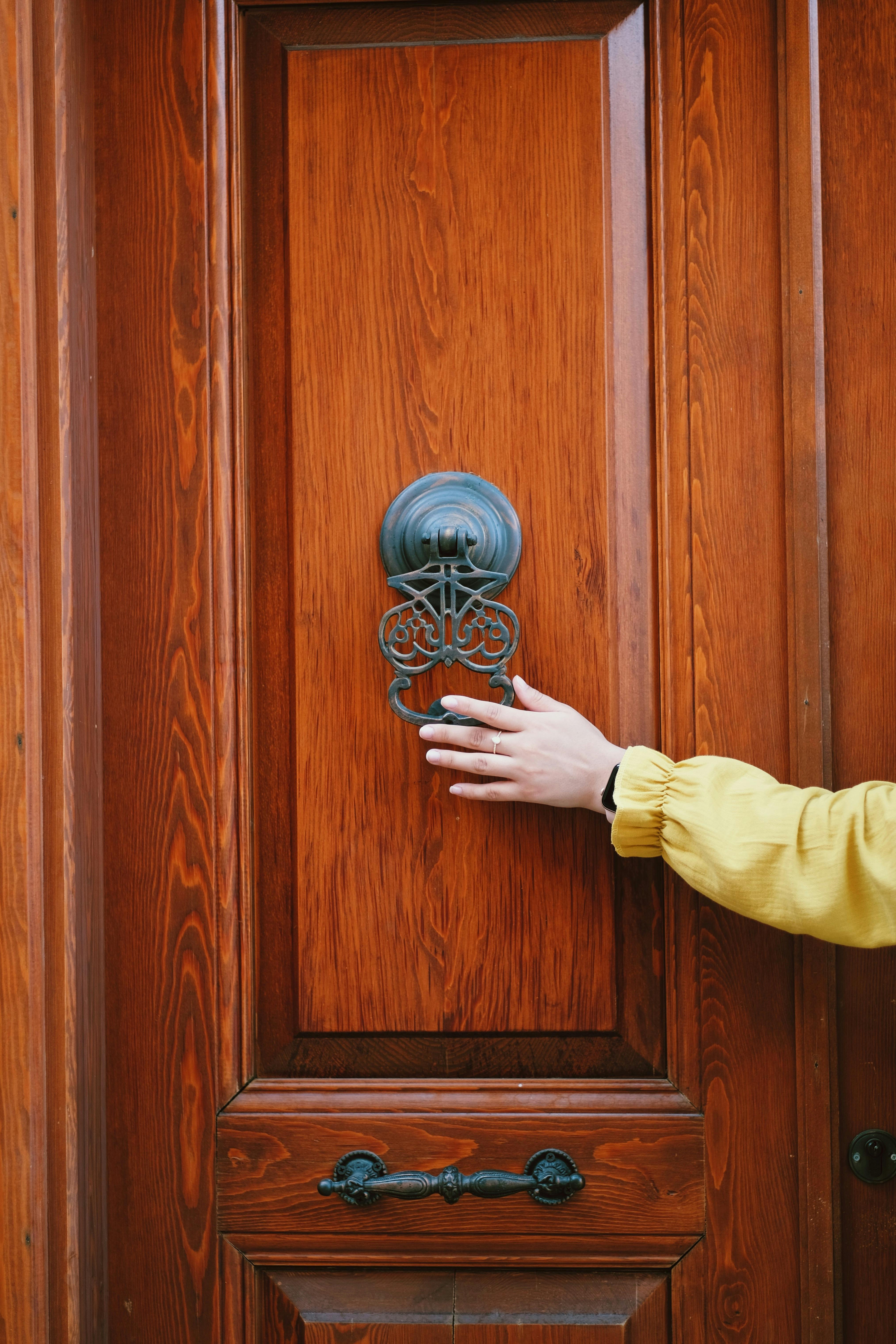 A person holding a door knocker | Source: Pexels