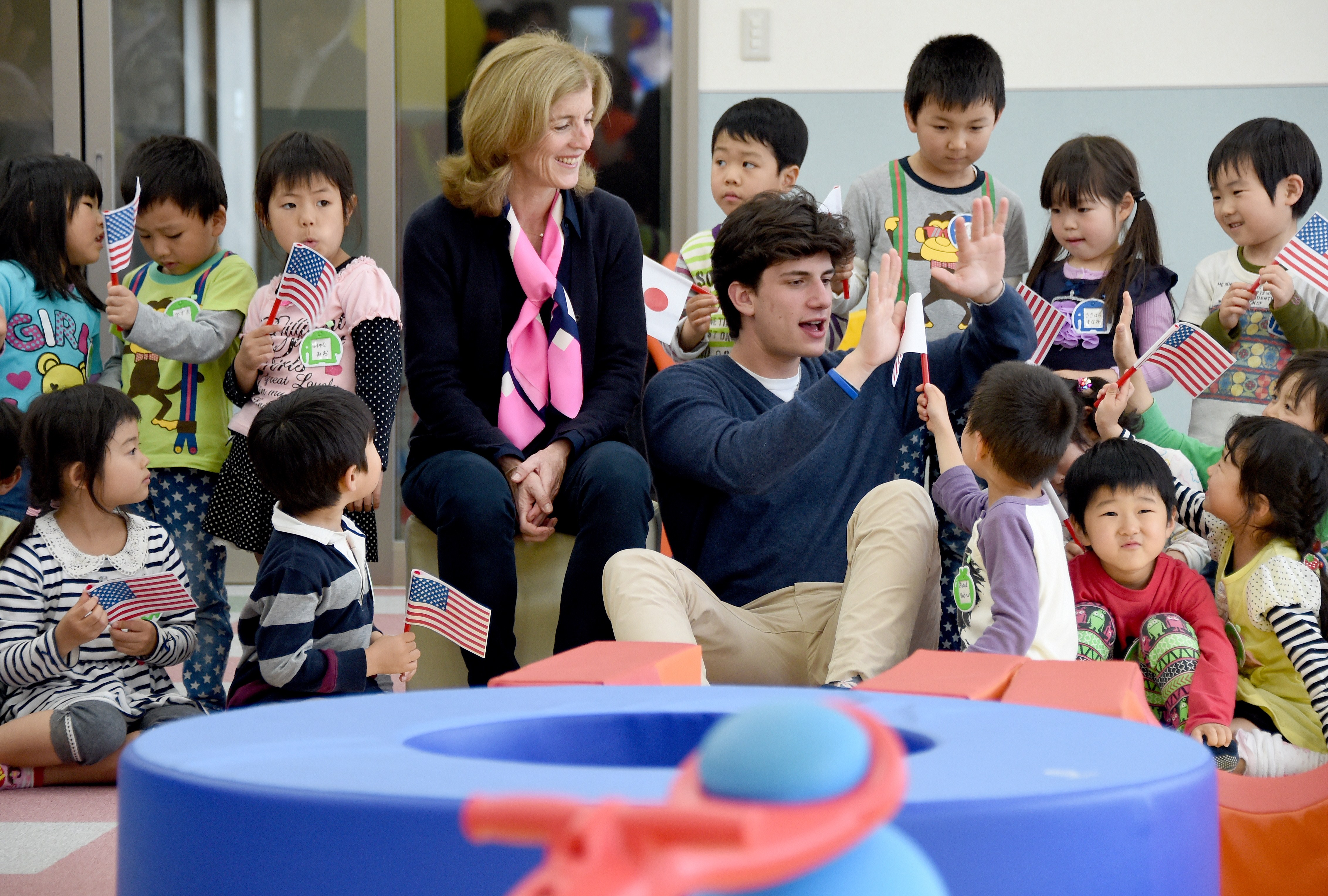 Caroline Kennedy and Jack Schlossberg playing with children at Child House Fukumaru, a center created to support children orphaned by the Great East Japan Earthquake in Iwaki, in Fukushima prefecture, Japan, on May 15, 2014. | Source: Getty Images