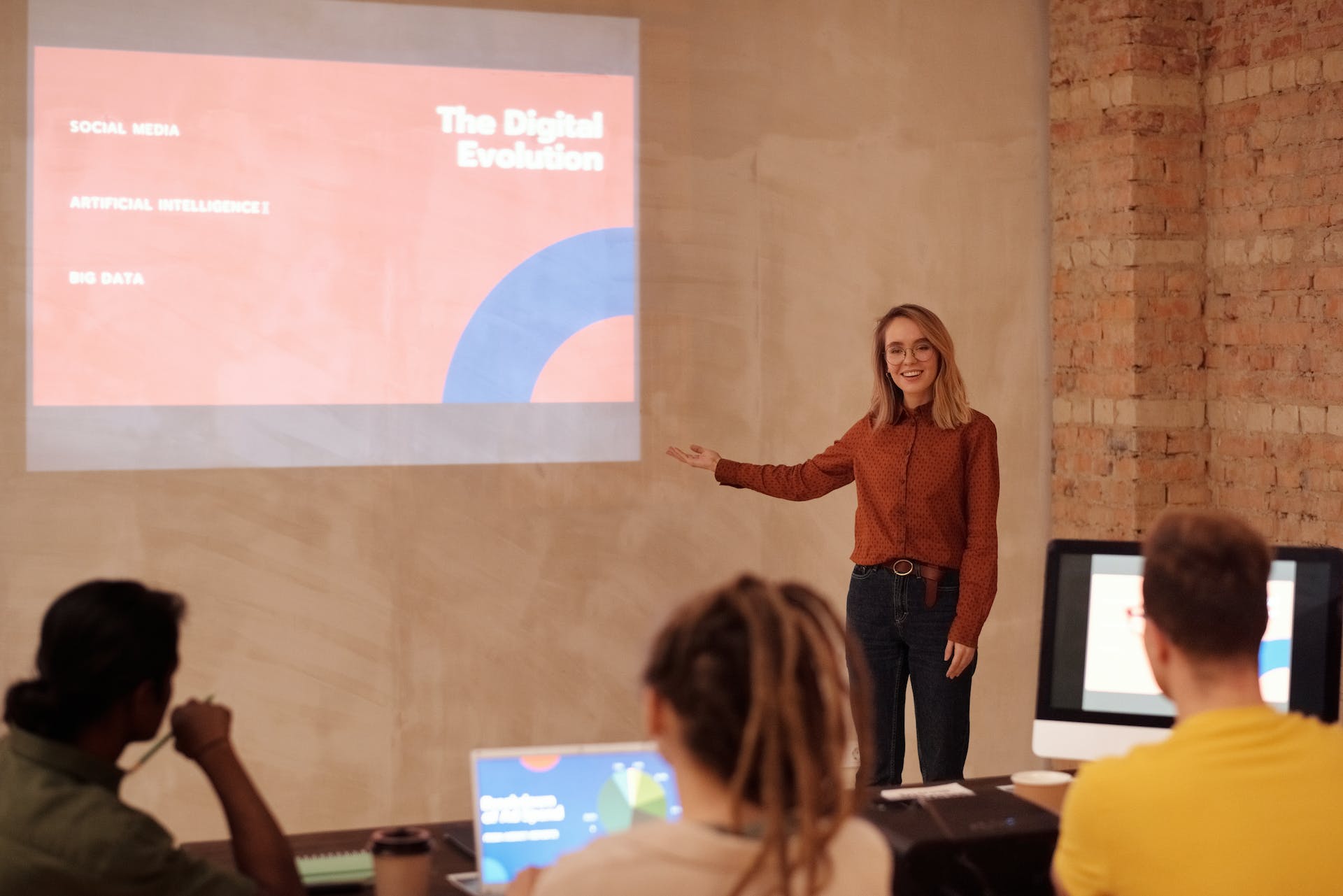 A woman presenting in front of a group of people | Source: Pexels