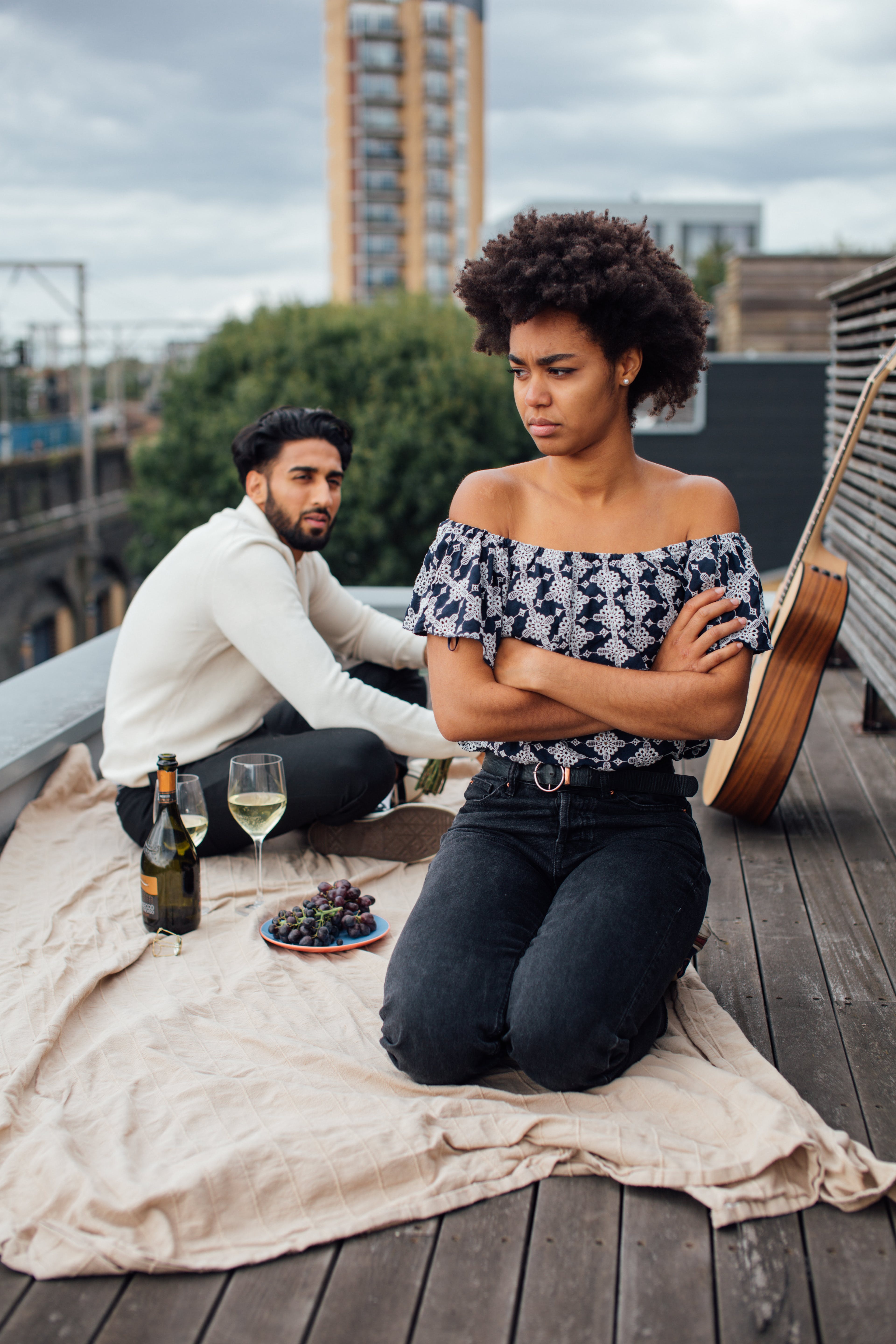 A biracial couple having a tense moment while enjoying while and grapes | Source: Pexels