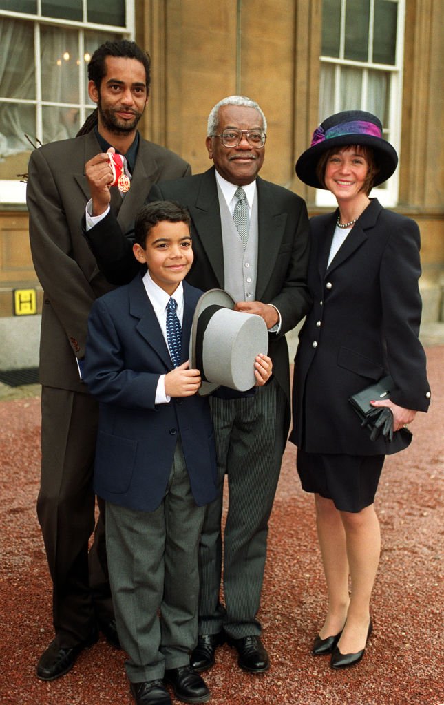 Sir Trevor McDonald with his family (L-R) son Tim, 32, son Jack, 10 and wife Josephine at Buckingham Palace on November 30, 1999. | Photo: Getty Images
