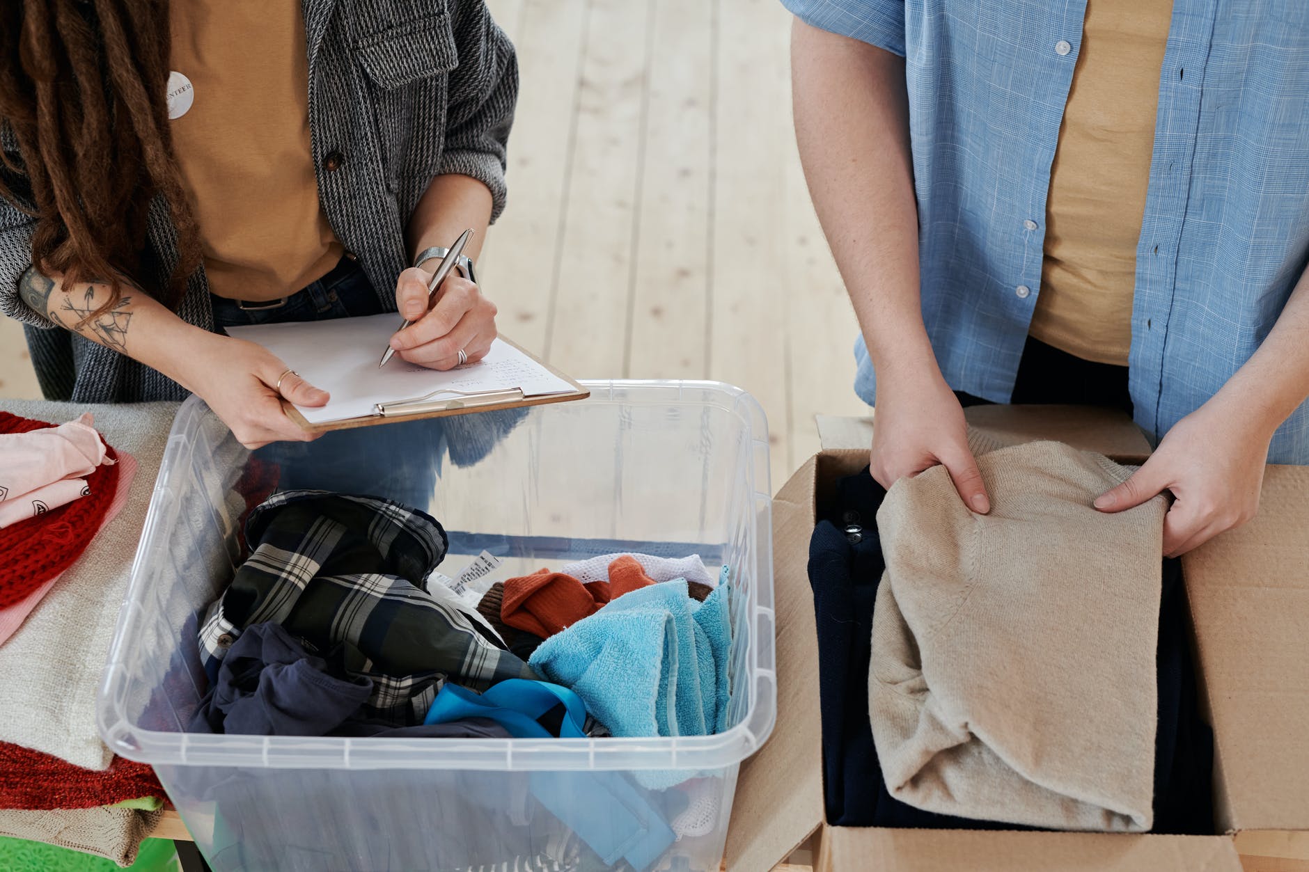 Personas organizando ropa. | Foto: Pexels