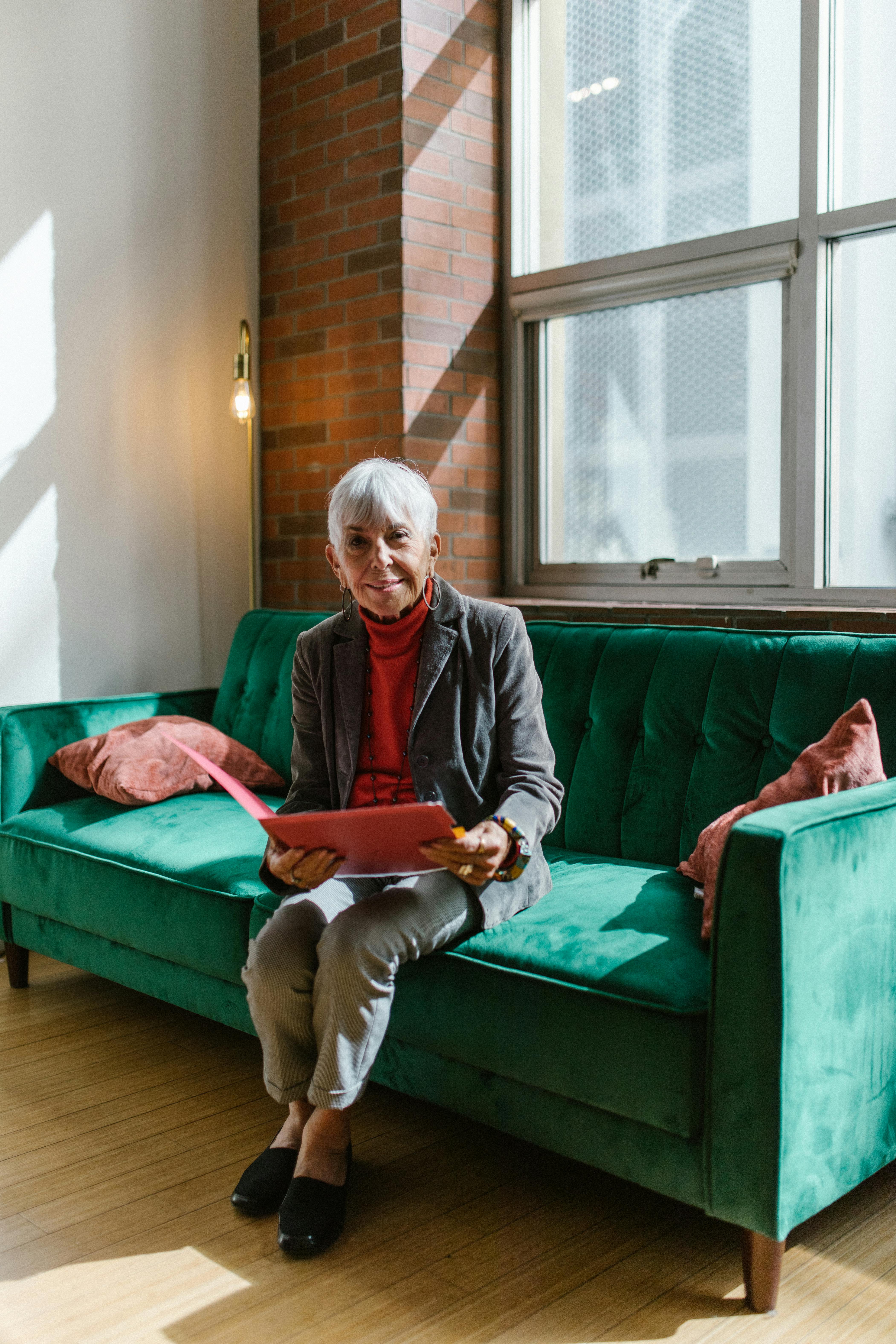 A woman sitting on a couch with a file | Source: Pexels