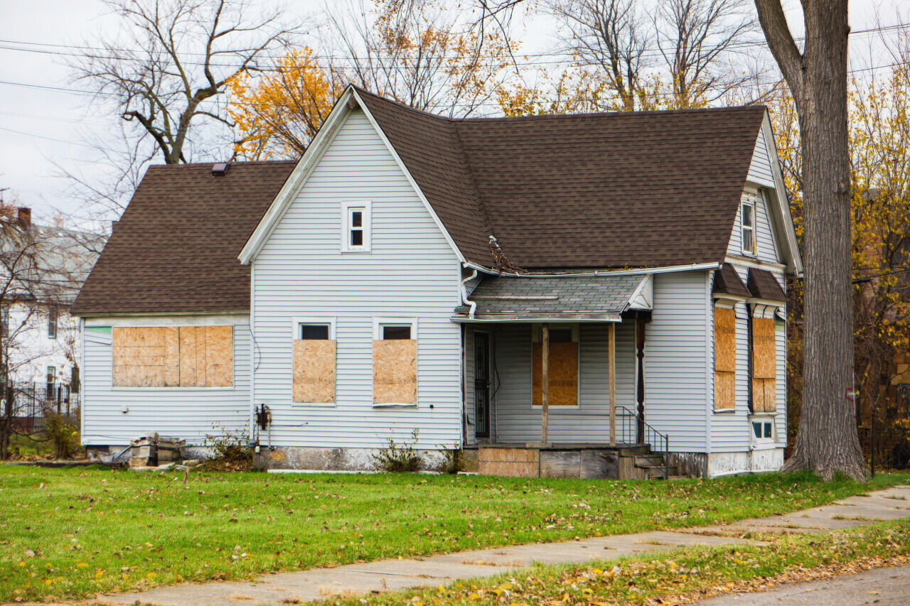 A weathered house with boarded-up windows | Source: Shutterstock