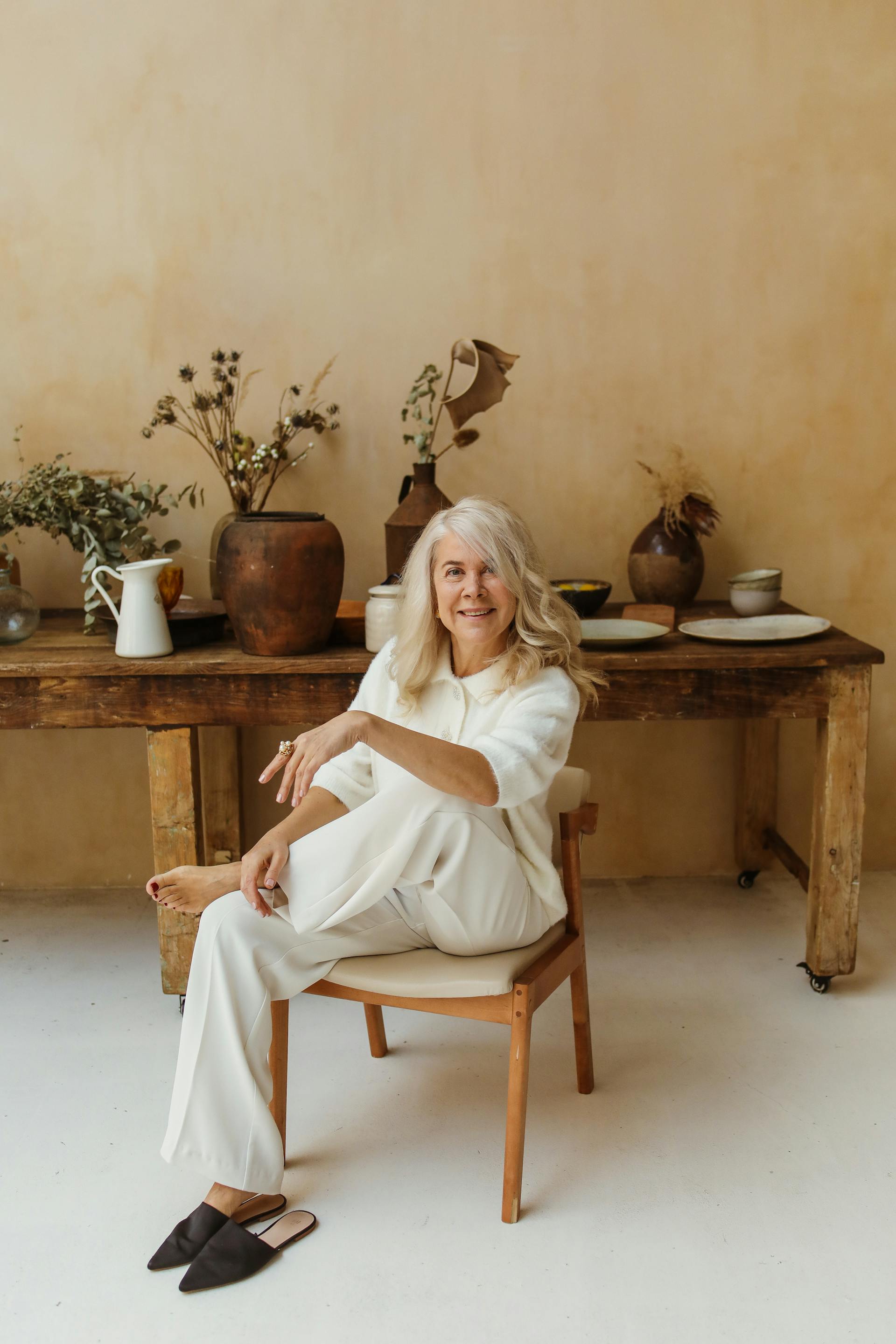 A smiling senior woman on a wooden chair | Source: Pexels