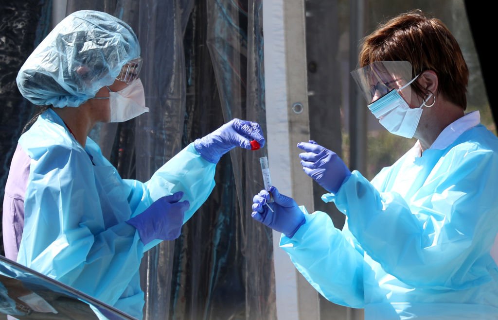 Medical personnel secure a sample from a person at a drive-thru Coronavirus COVID-19 testing station on March 12, 2020. | Photo :Getty Images