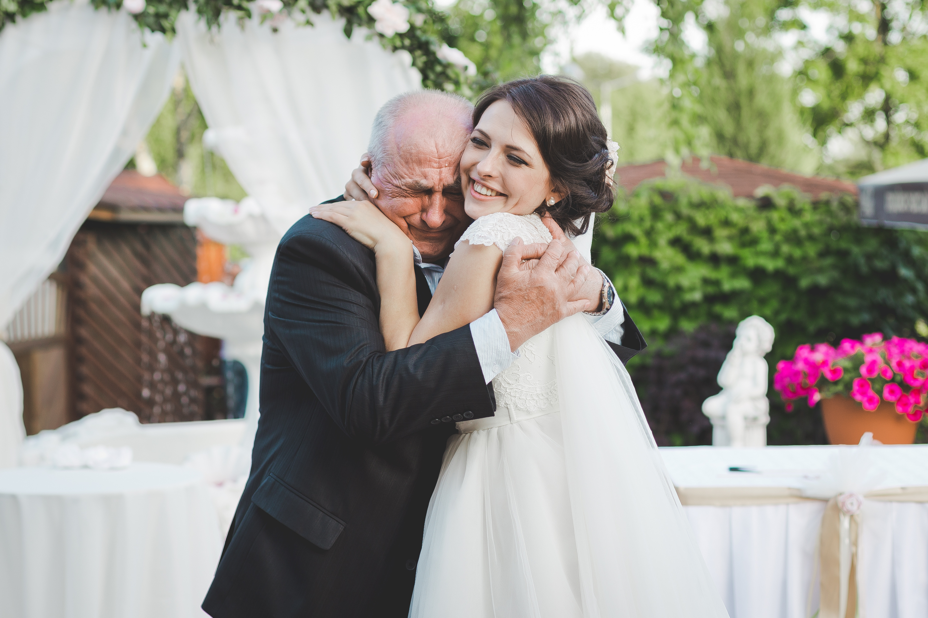 Bride smiles while hugging an older man | Source: Shutterstock