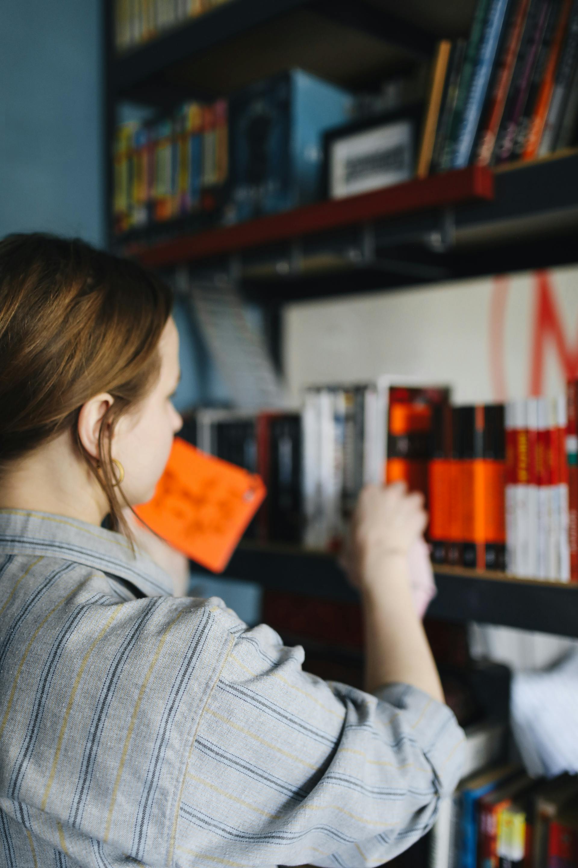 A woman wiping a shelf in a bookstore | Source: Pexels