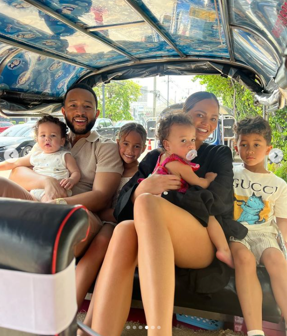 A screenshot of Chrissy Teigen, John Legend, and their four children inside a tuk-tuk in Thailand. | Source: Instagram/chrissyteigen