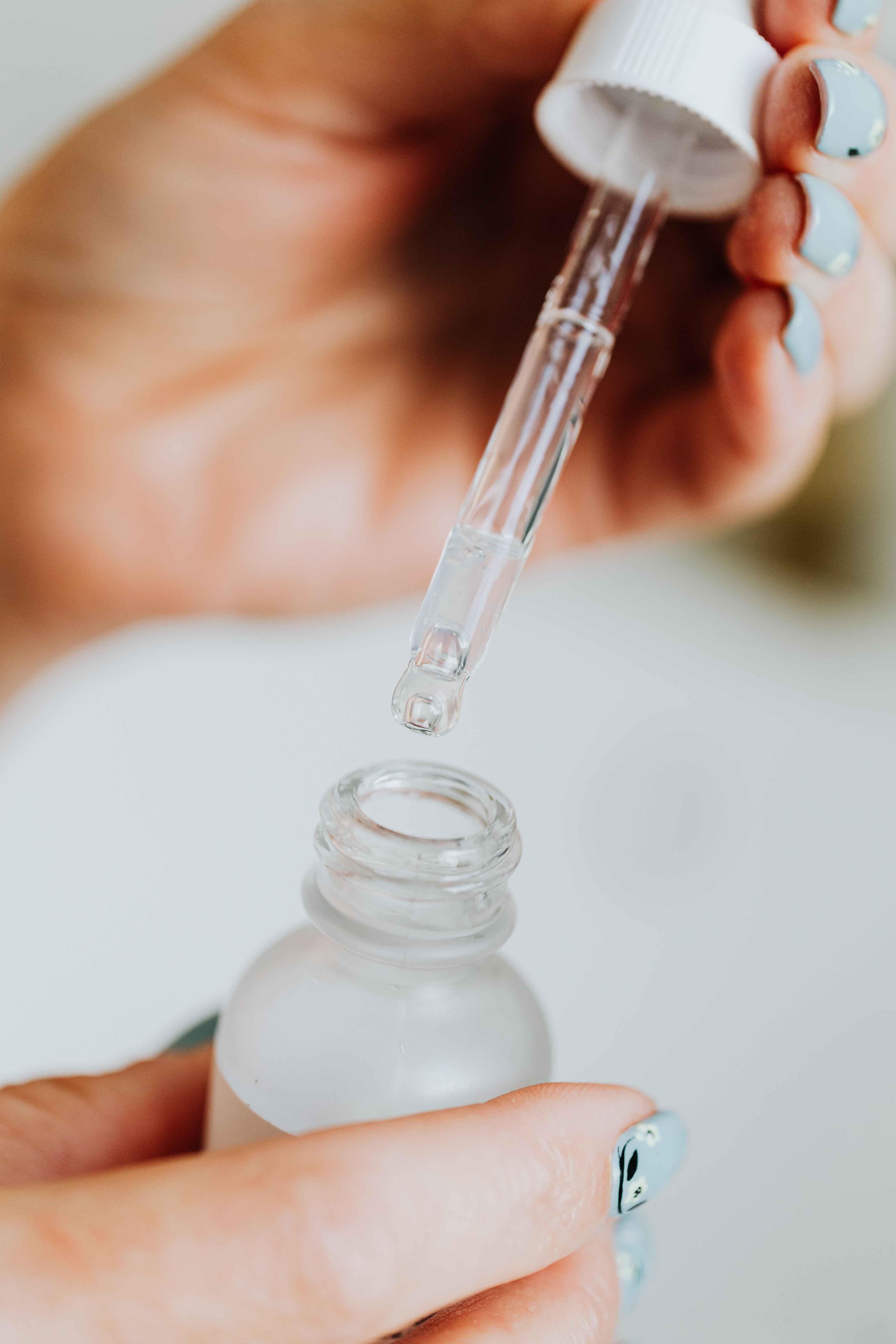 A woman takes out a solution from the small bottle. | Source: Pexels