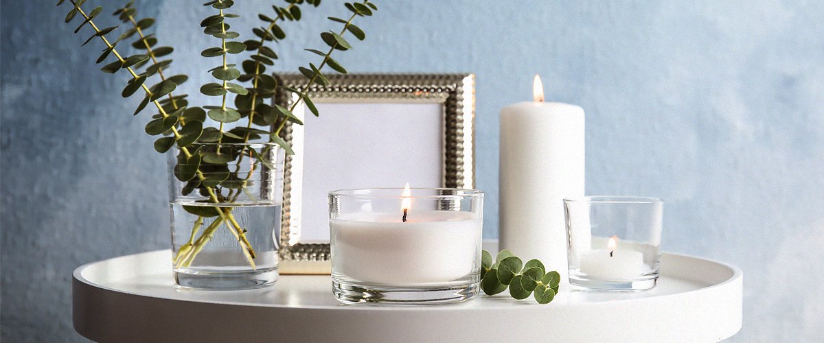 Composición con velas aromáticas encendidas en la mesa junto a la pared. | Foto: Shutterstock
