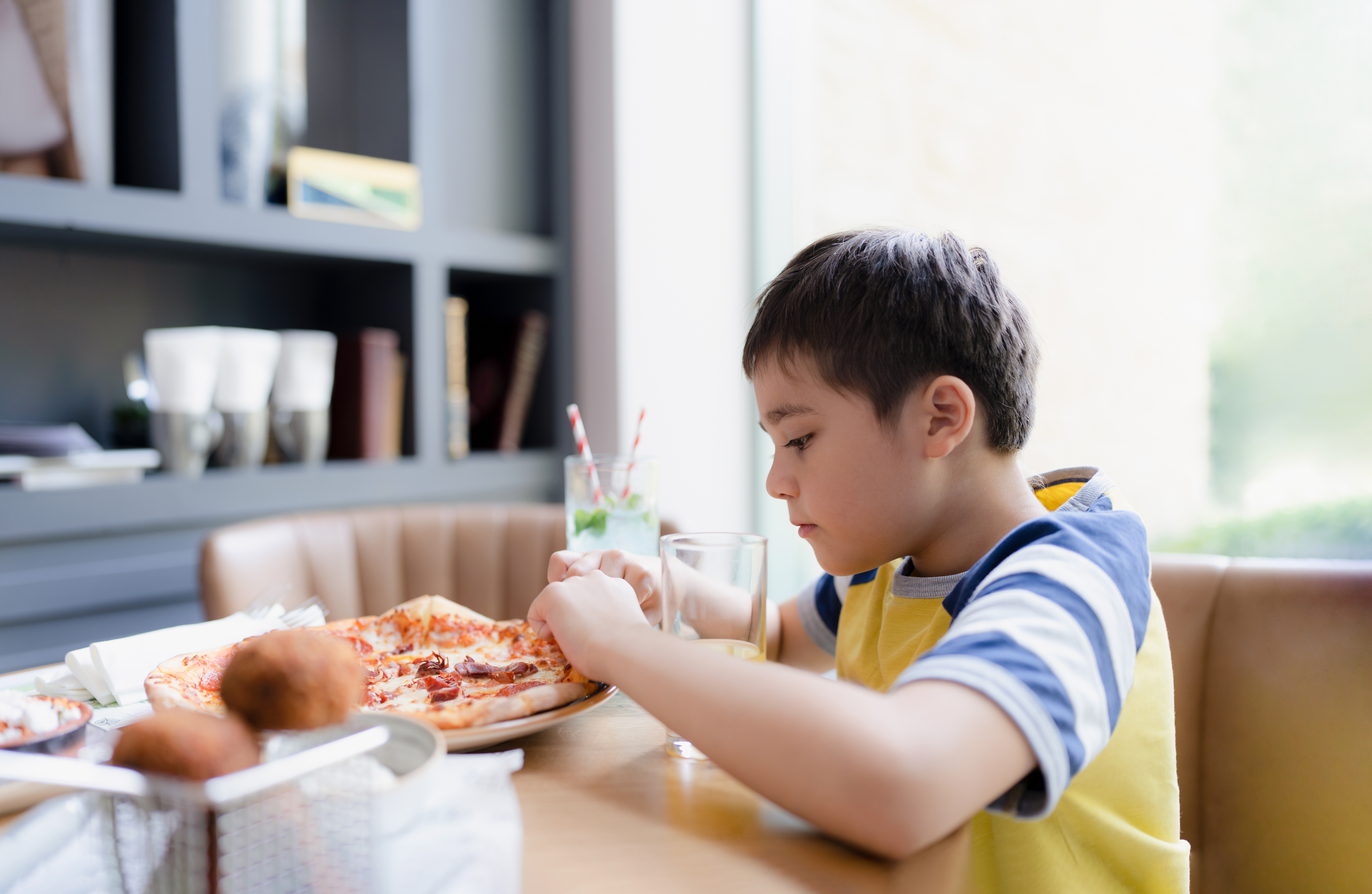 Boy eating pizza | Source: Shutterstock