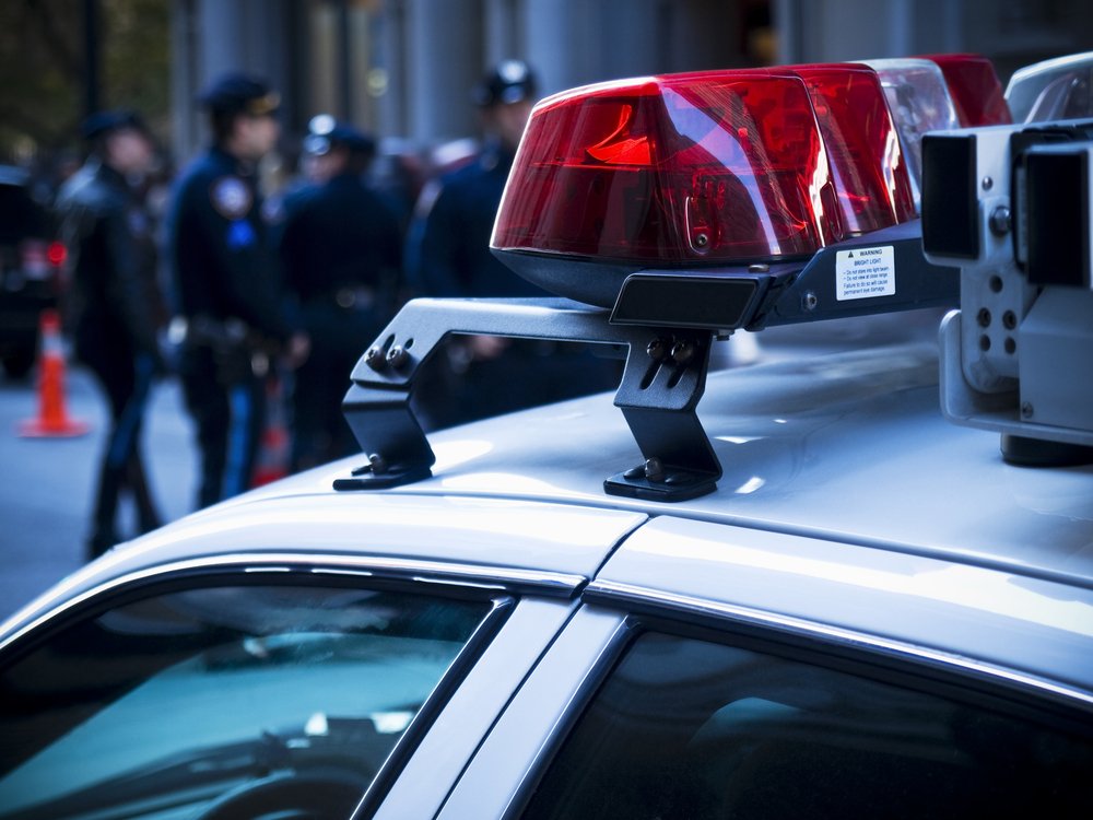 Vehículo patrulla de policía y oficiales al fondo. | Foto: Shutterstock
