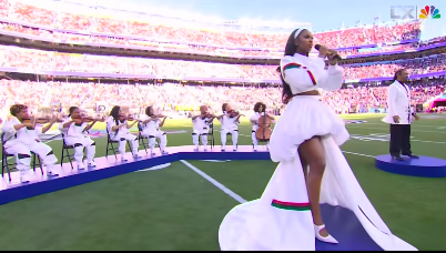 Coco Jones awaiting her cue to begin singing as the orchestra and ASL interpreter follow along, posted on February 8, 2026. | Source: Facebook/Essence