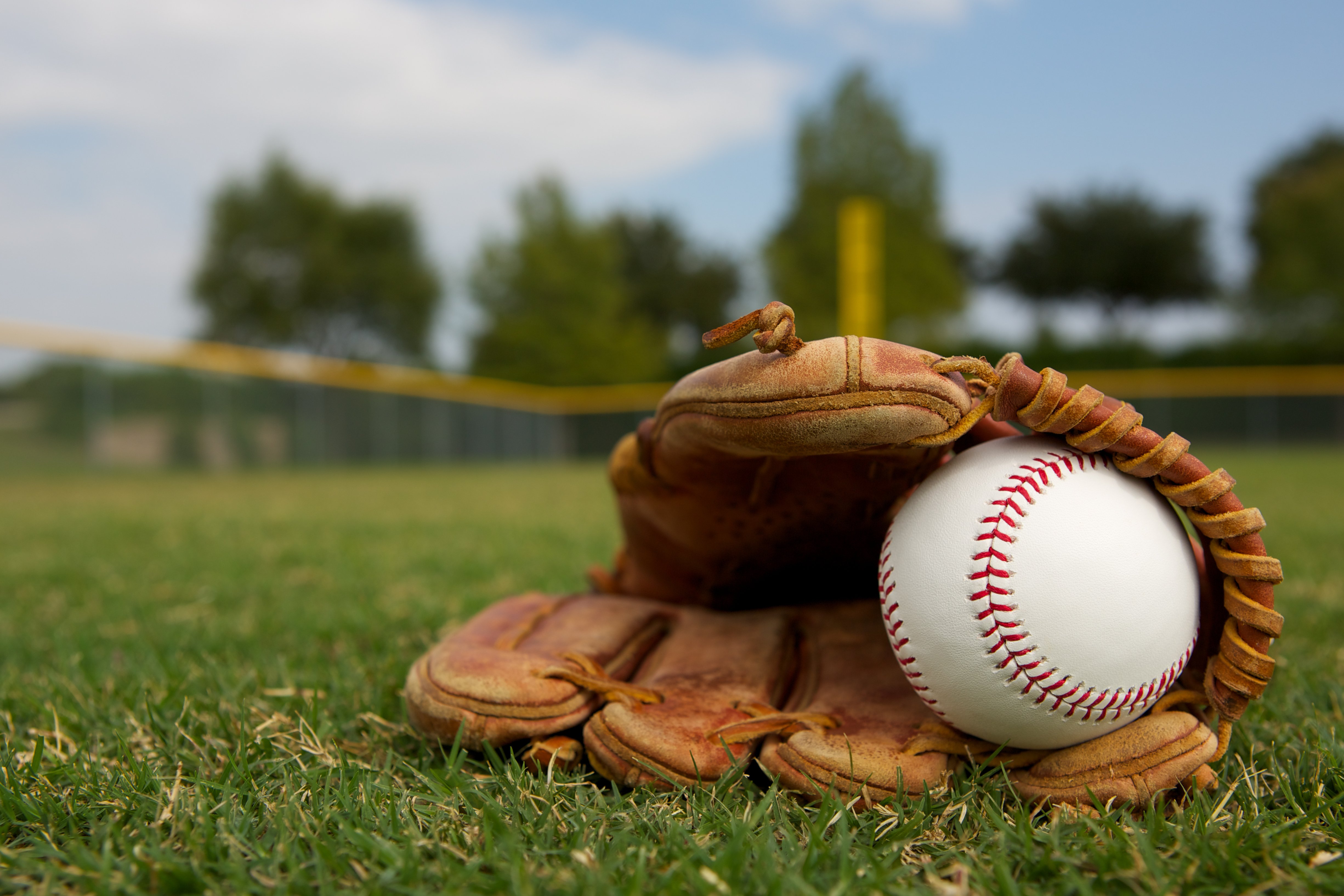 Baseball in a glove in the outfield | Photo: Shutterstock