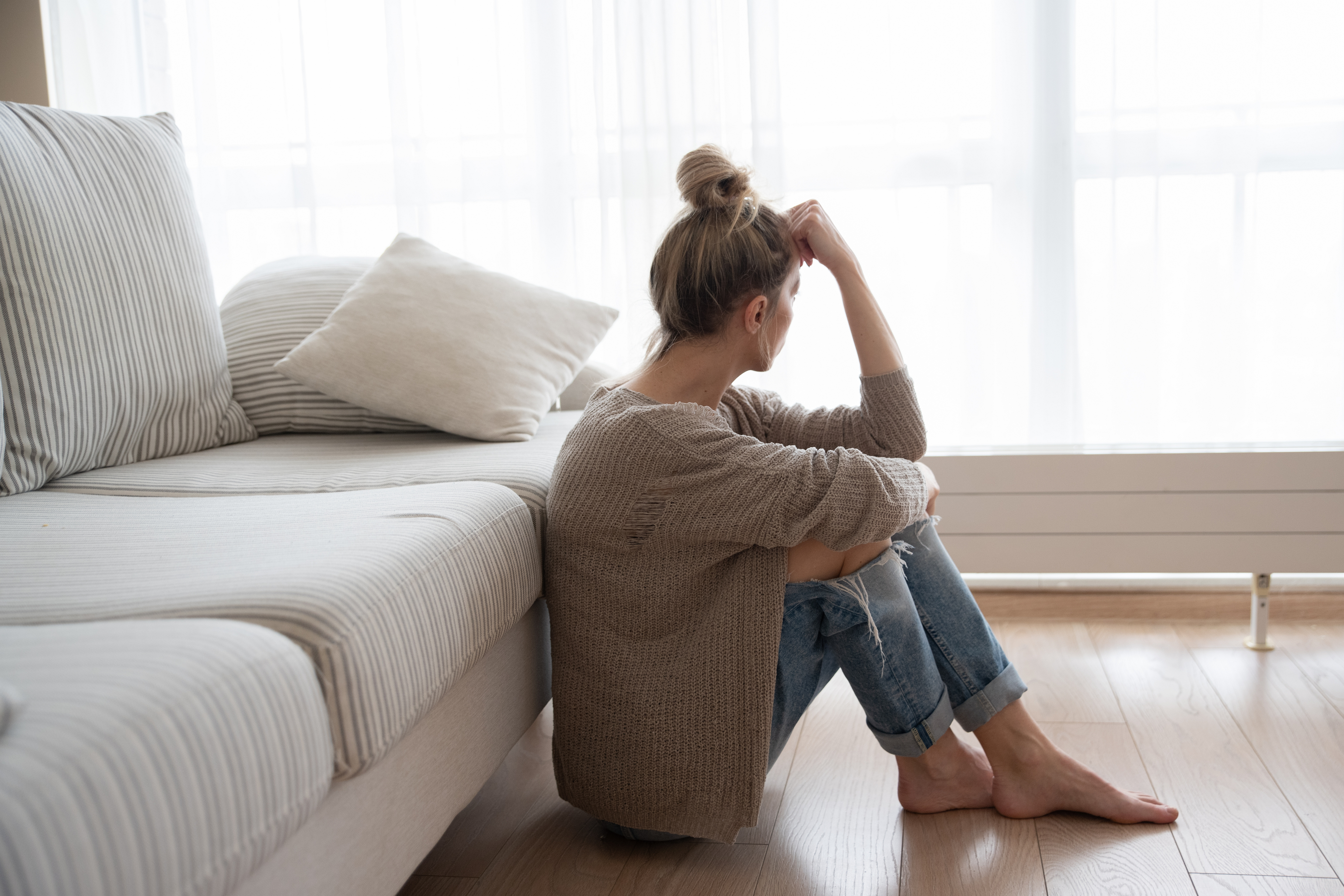 A depressed woman sitting on the floor | Source: Shutterstock