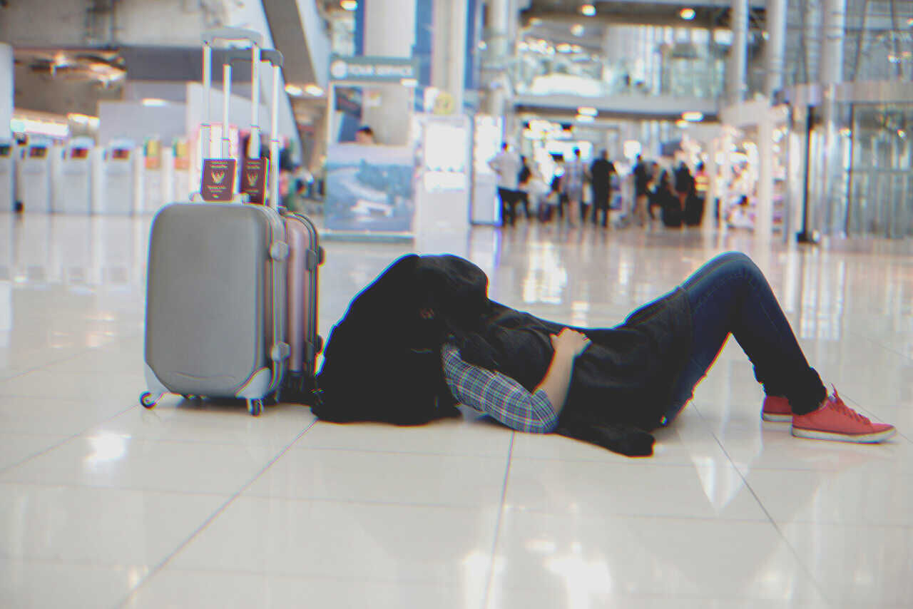 Man lying on airport floor | Source: Shutterstock