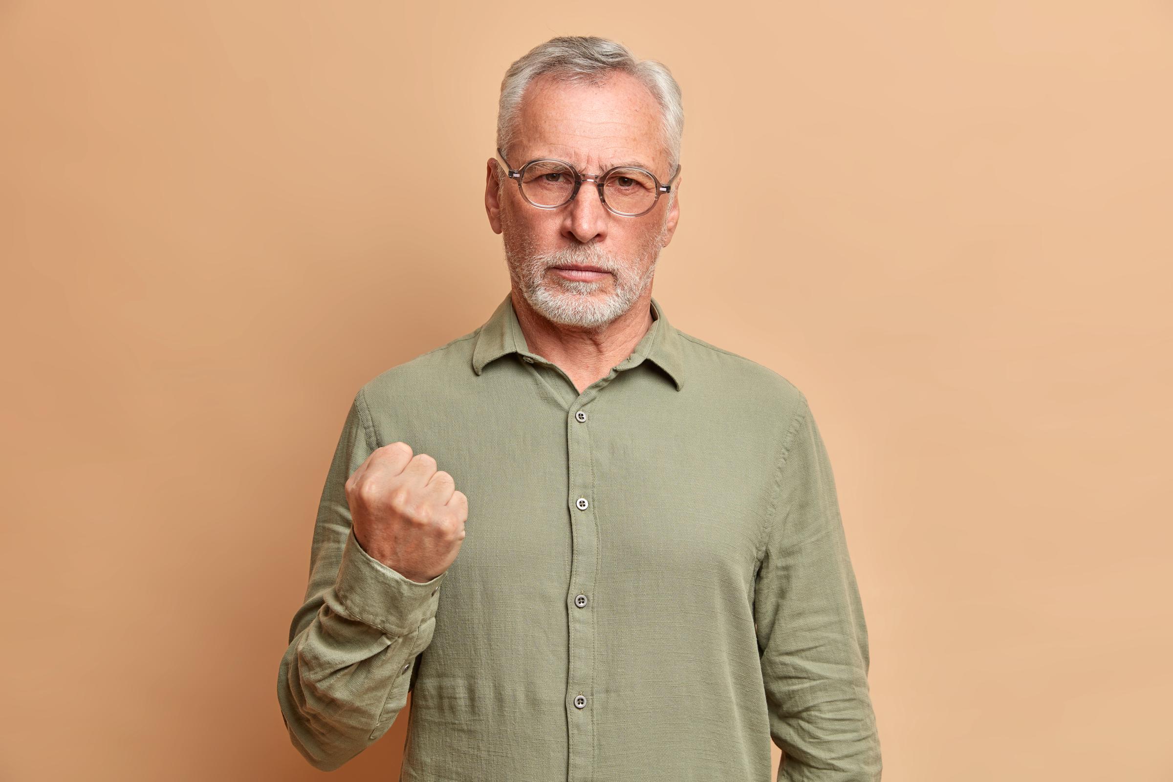 A middle-aged man holding a fist | Source: Freepik