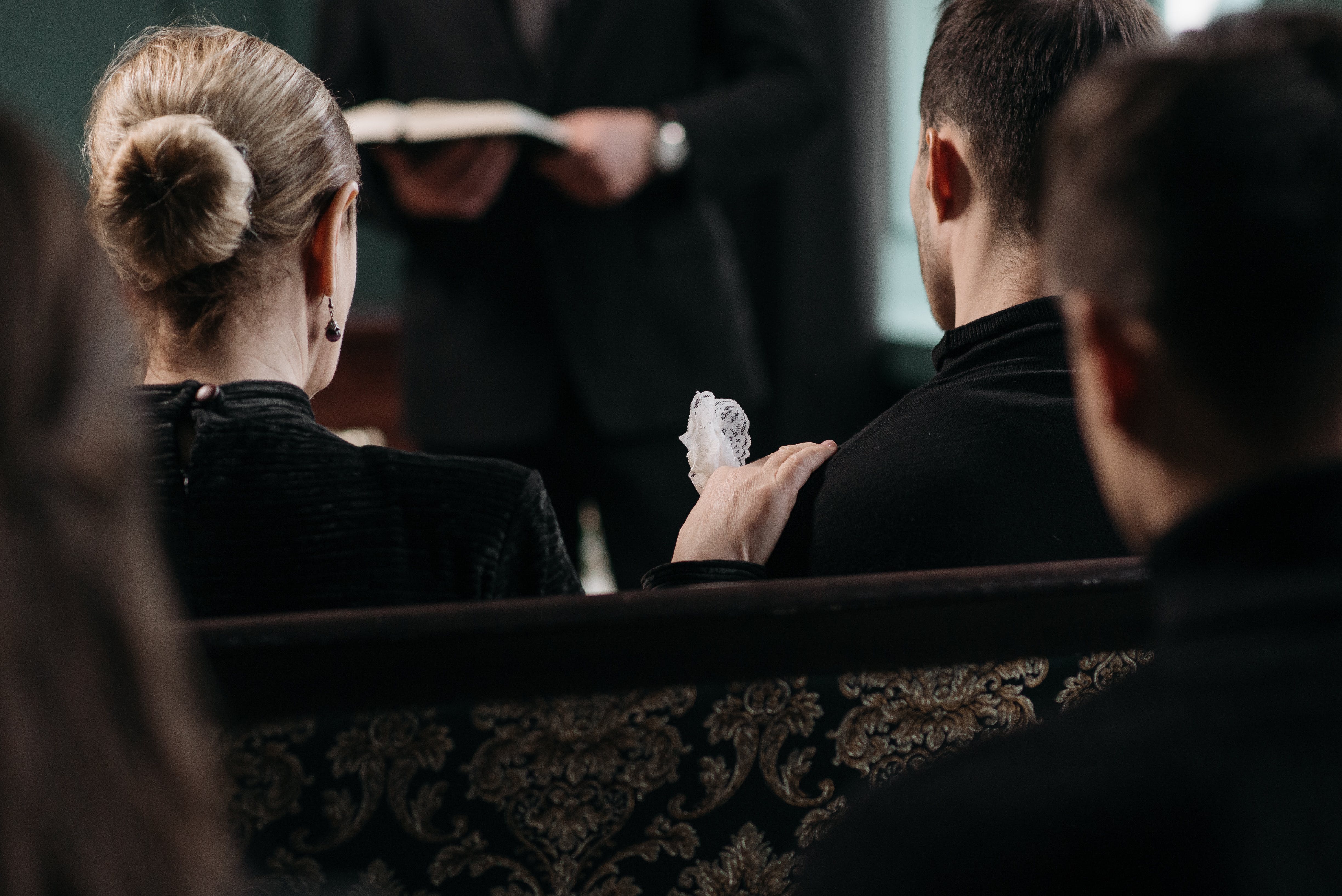 People sited at a funeral. | Source: Pexels