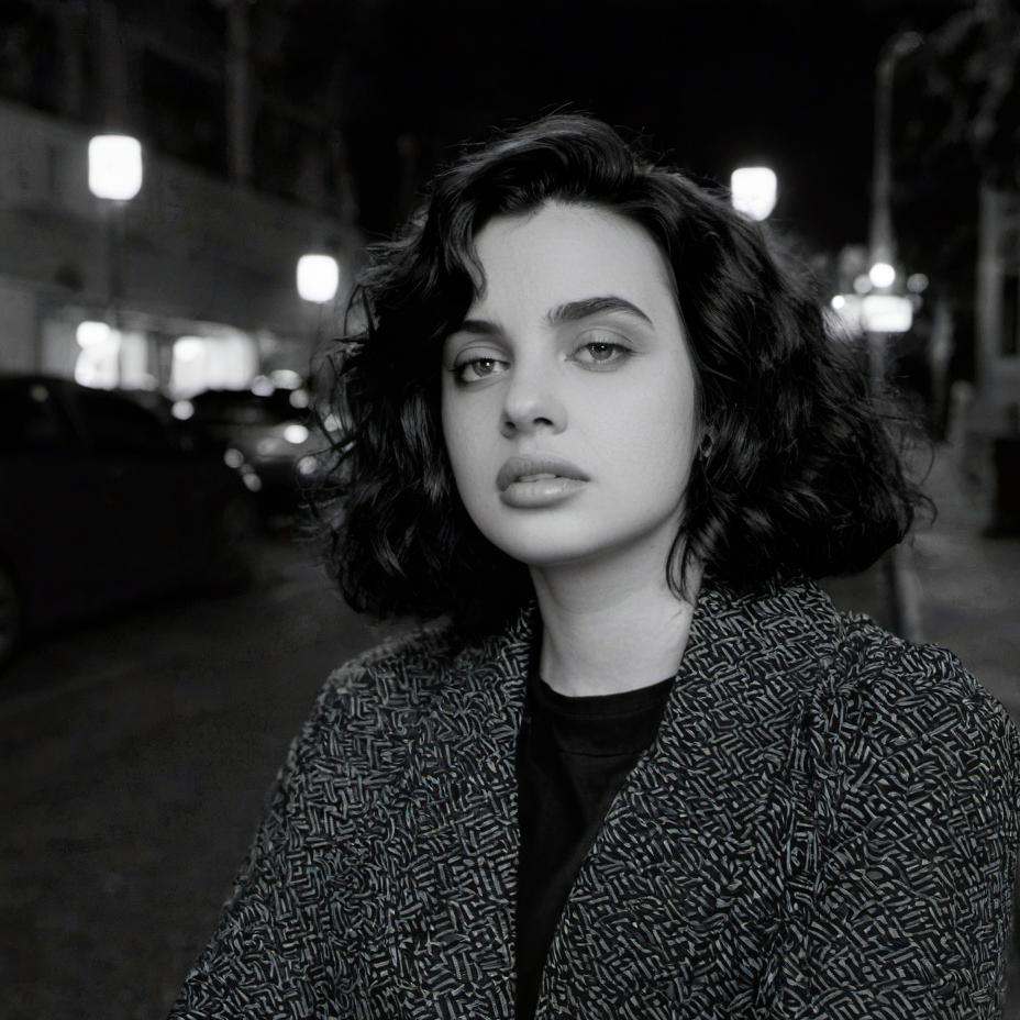 A thoughtful-looking woman on a city street at night | Source: Midjourney