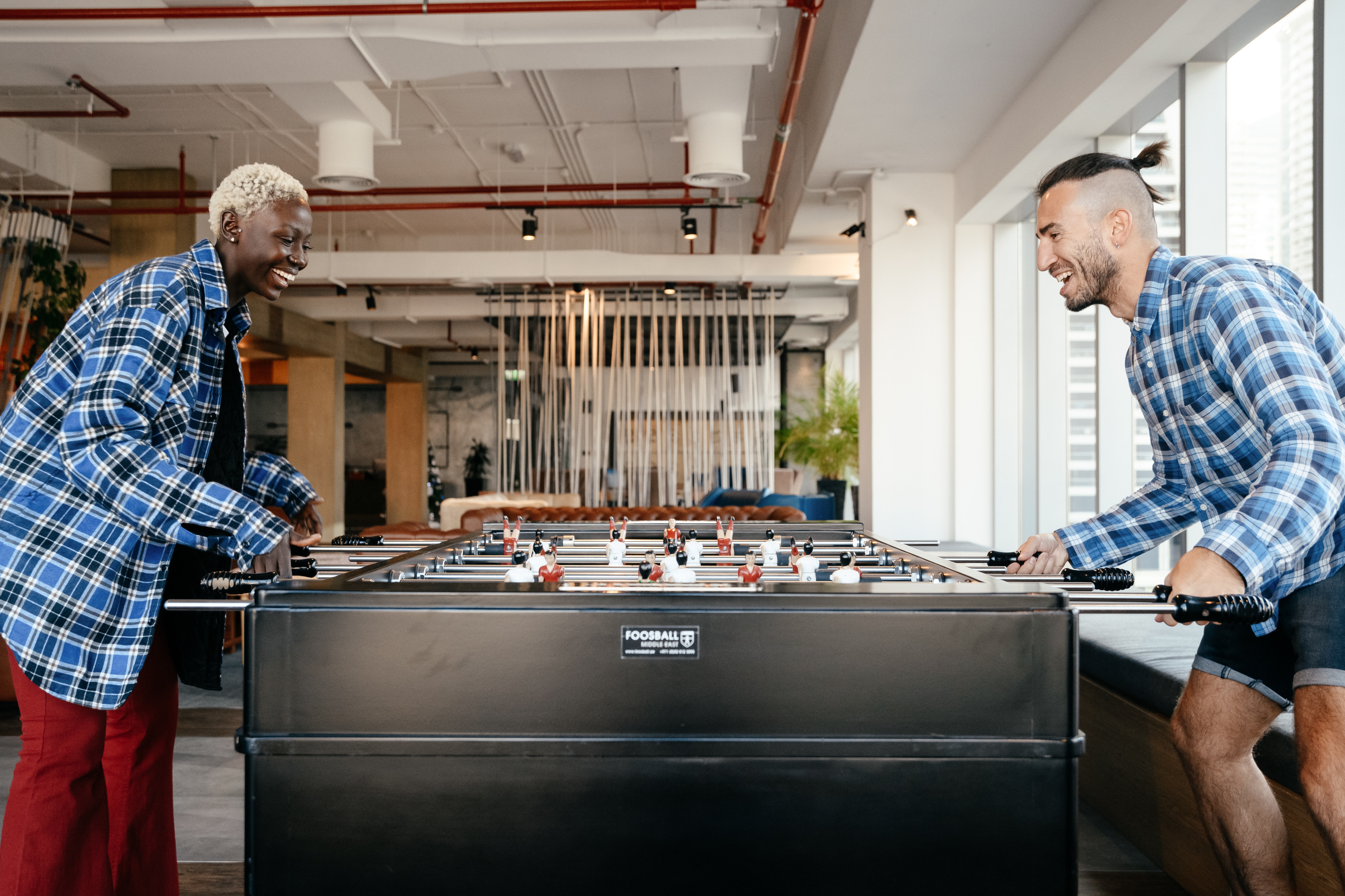 A couple playing foosball.  | Source: Pexels