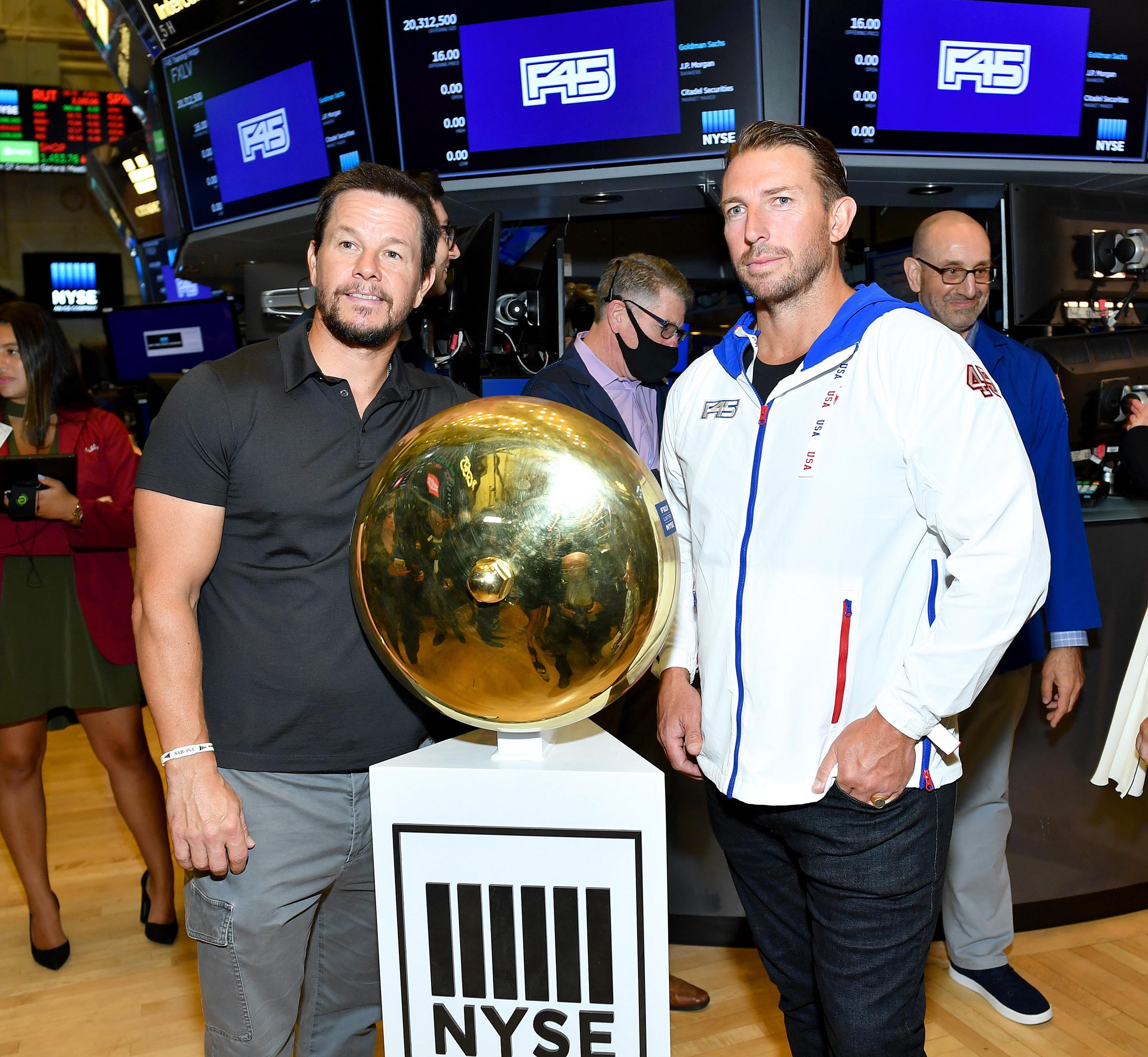 Mark Wahlberg and F45 Founder and CEO Adam Gilchrist pose on the trading floor as they rings the opening bell at the New York Stock Exchange on July 15, 2021. | Source: Getty Images