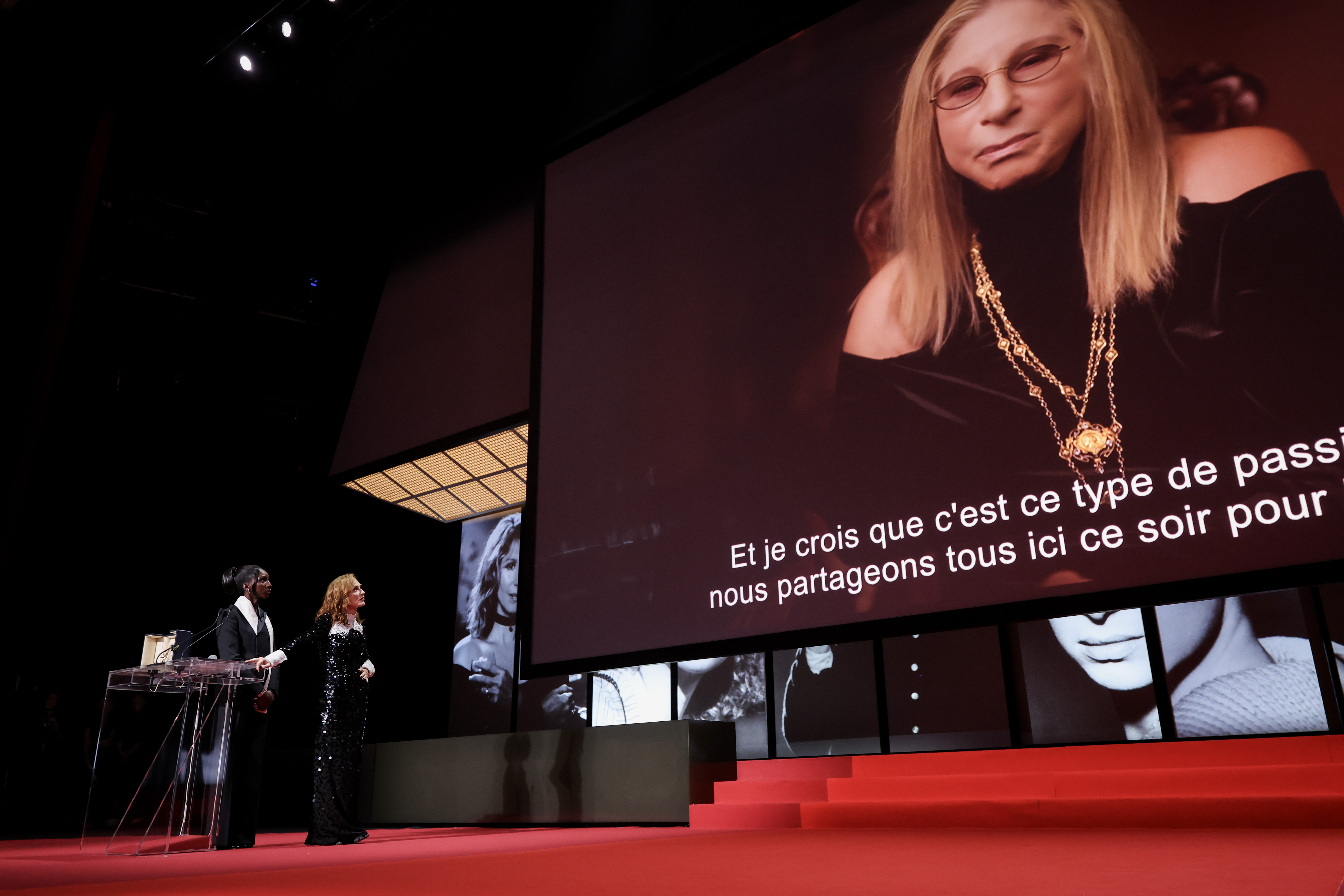 Barbra Streisand's pre-recorded speech plays after Isabelle Huppert accepted the Honorary Palme d'Or on her behalf from host Eye Haïdara on stage during the closing ceremony of the 79th annual Cannes Film Festival at Palais des Festivals on May 23, 2026 in France. | Source: Getty Images