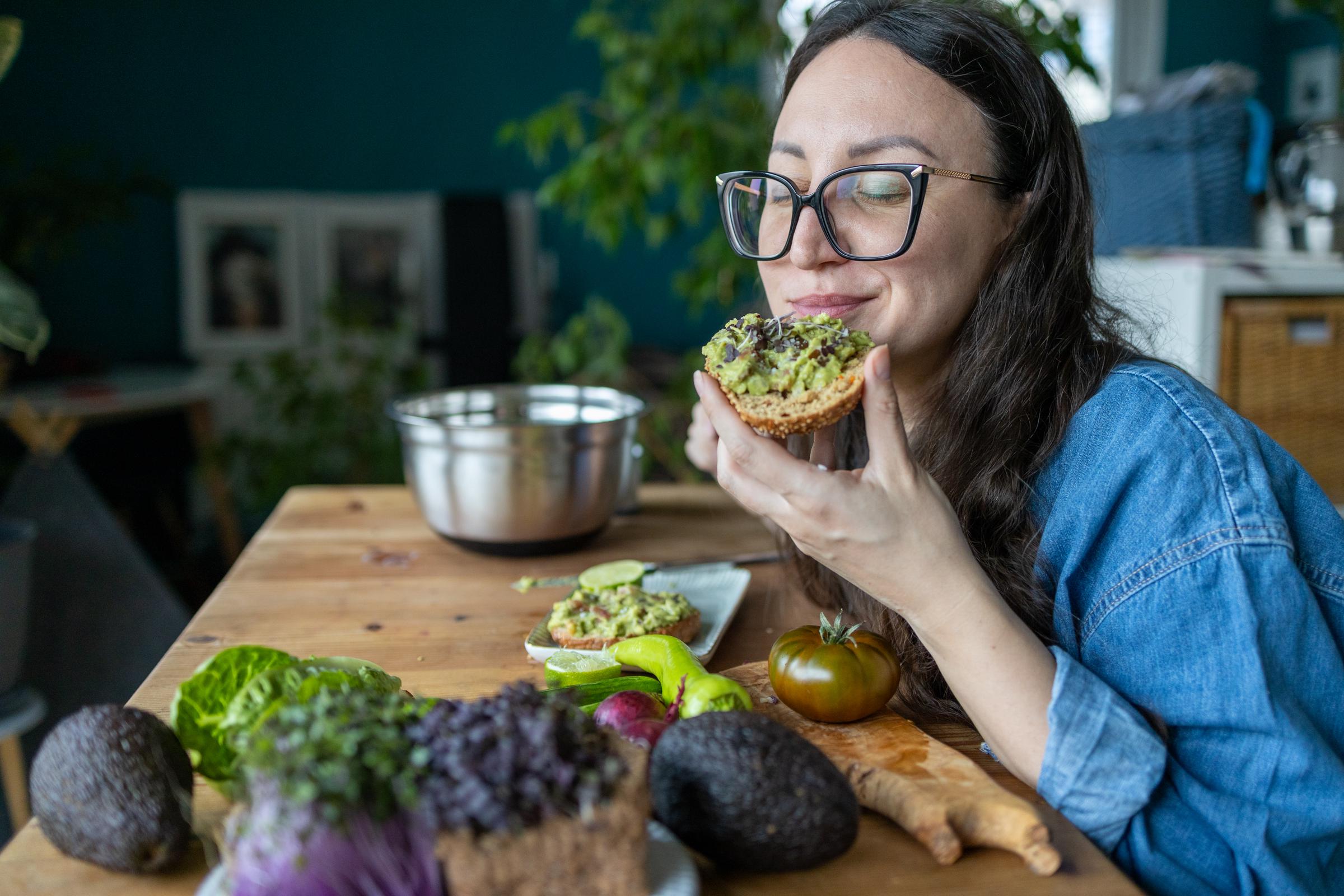 A young woman enjoying home made avocado toast | Source: Getty Images