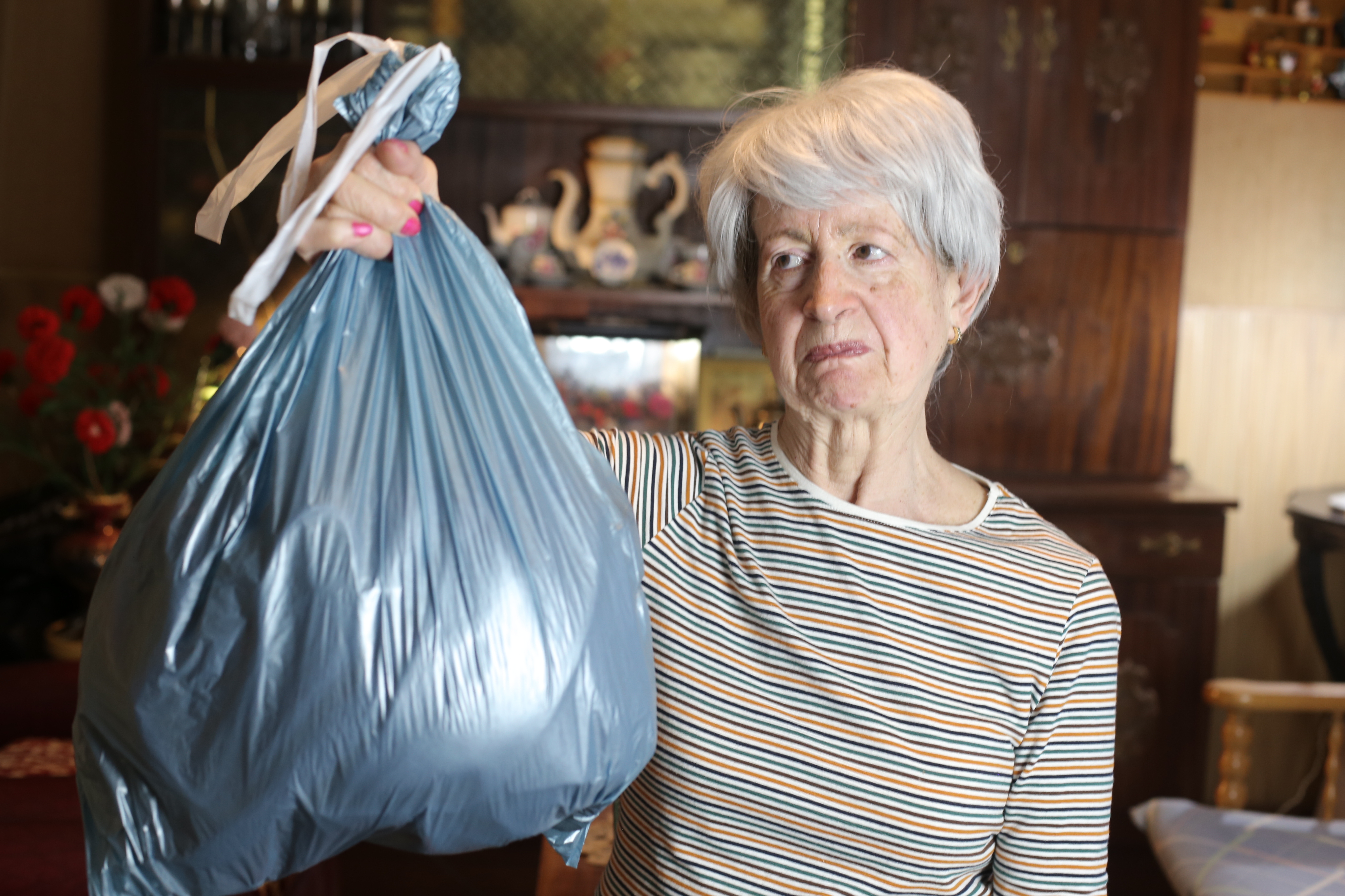 Senior woman holding a garbage bag | Source: Getty Images