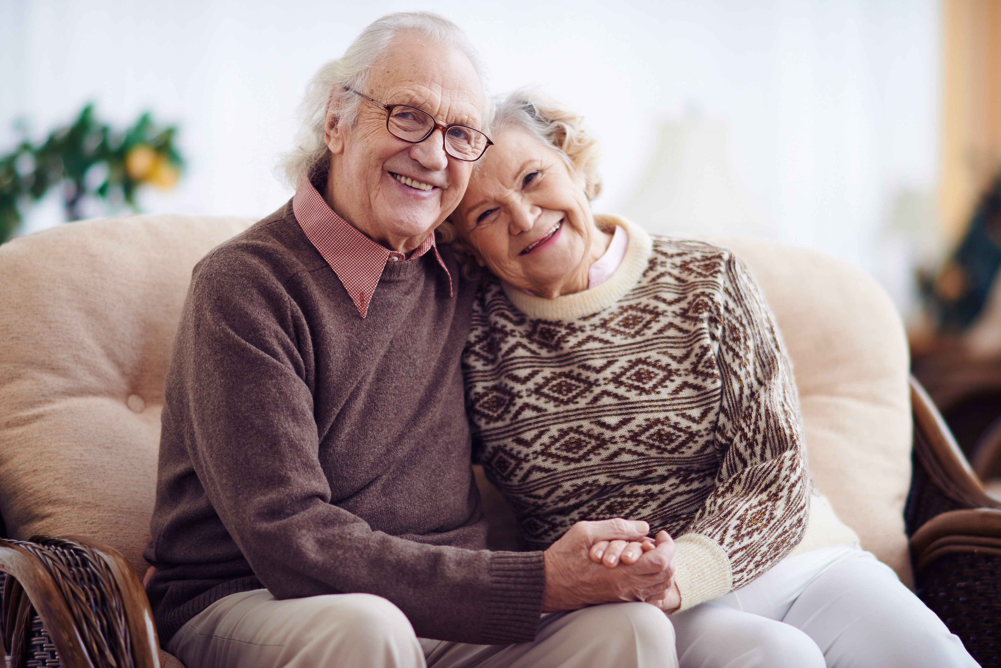 An older couple sitting on a couch | Source: Shutterstock