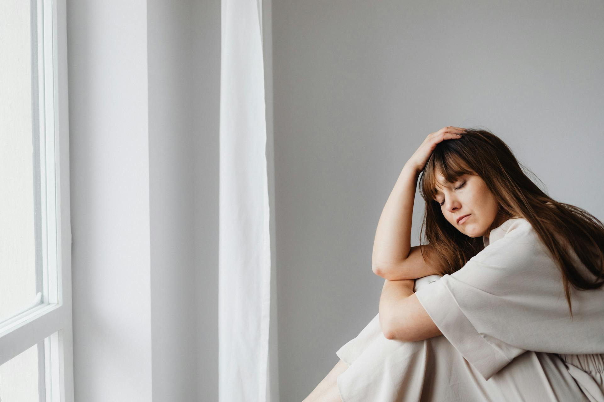 A frustrated woman sitting by a window | Source: Pexels